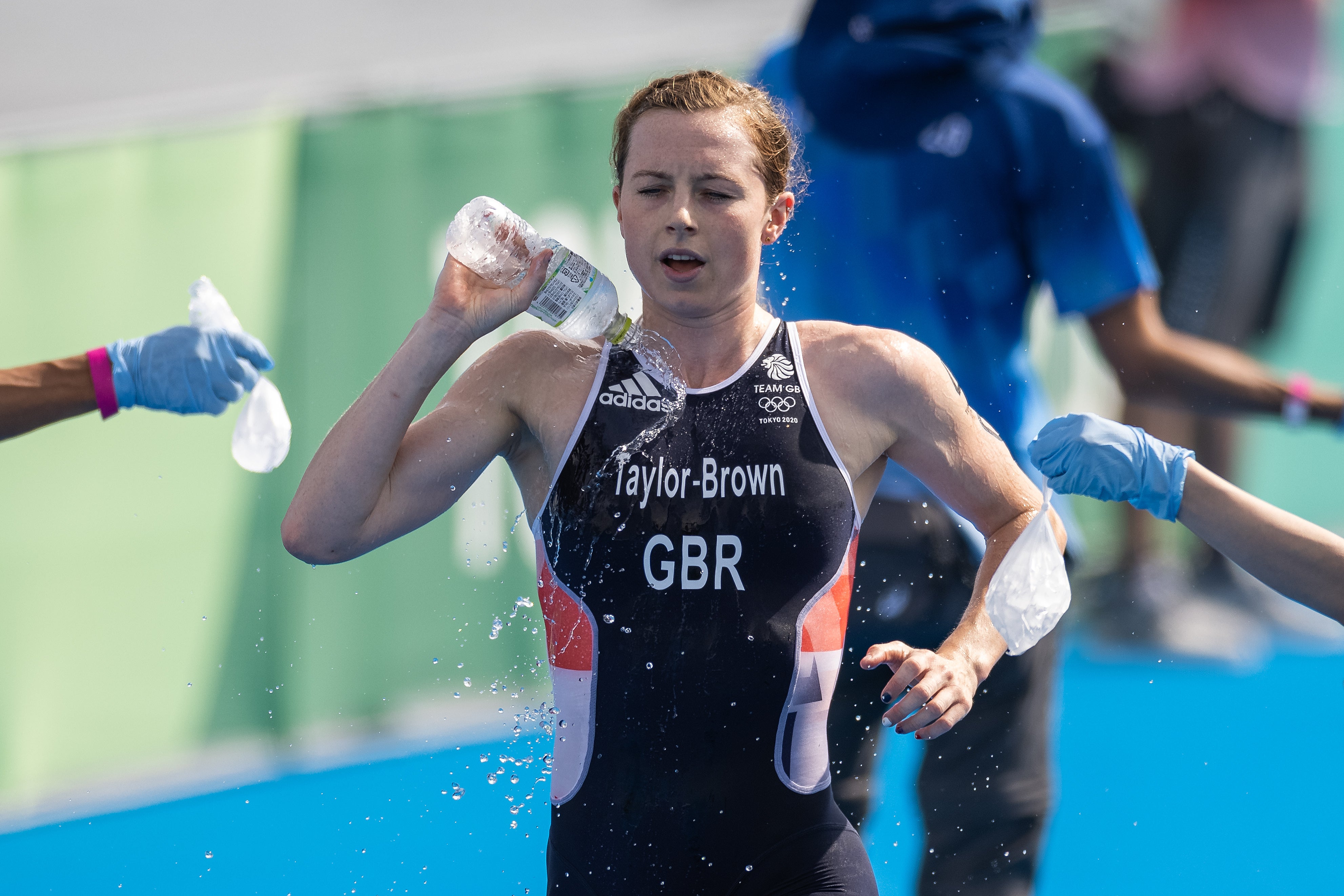 Georgia Taylor-Brown pours water over herself in testing conditions at Odaiba Marine Park