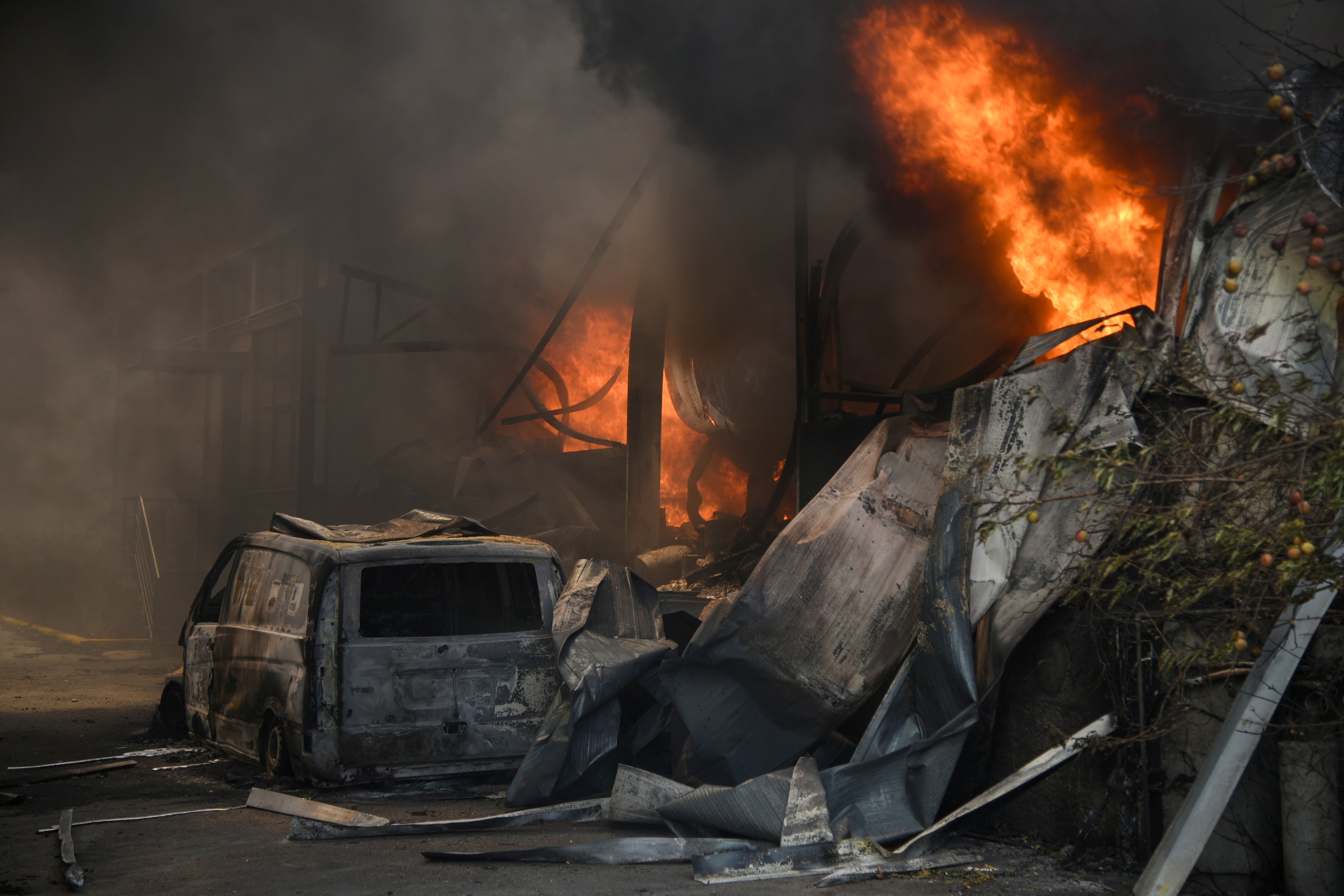 A burnt vehicle caught in a wildfire near the village of Afidnes