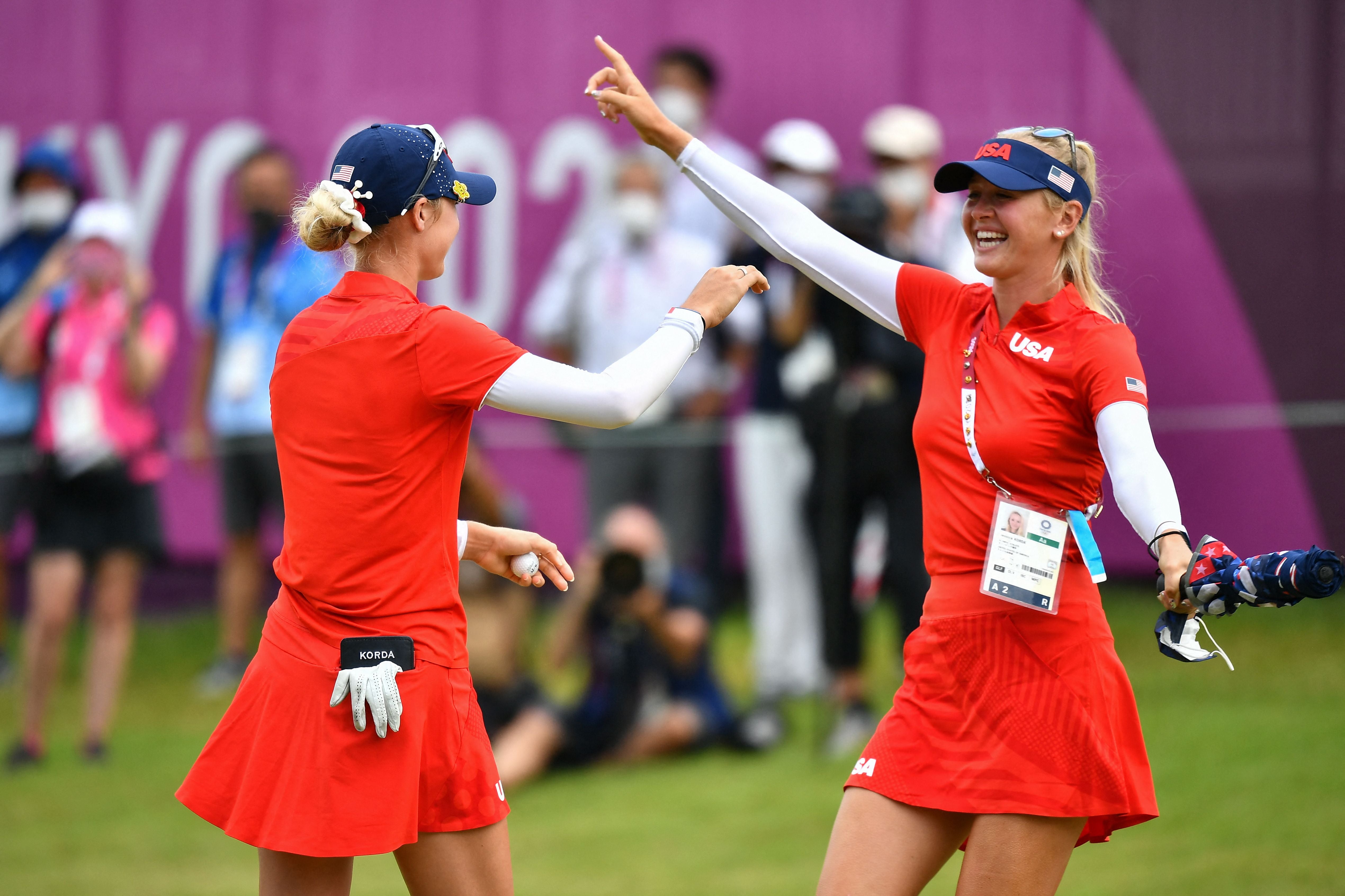 USA's Nelly Korda (L) is congratulated by her sister USA's Jessica Korda (R) after winning the gold medal in round 4 of the women’s golf individual stroke play during the Tokyo 2020 Olympic Games at the Kasumigaseki Country Club in Kawagoe on August 7 2021