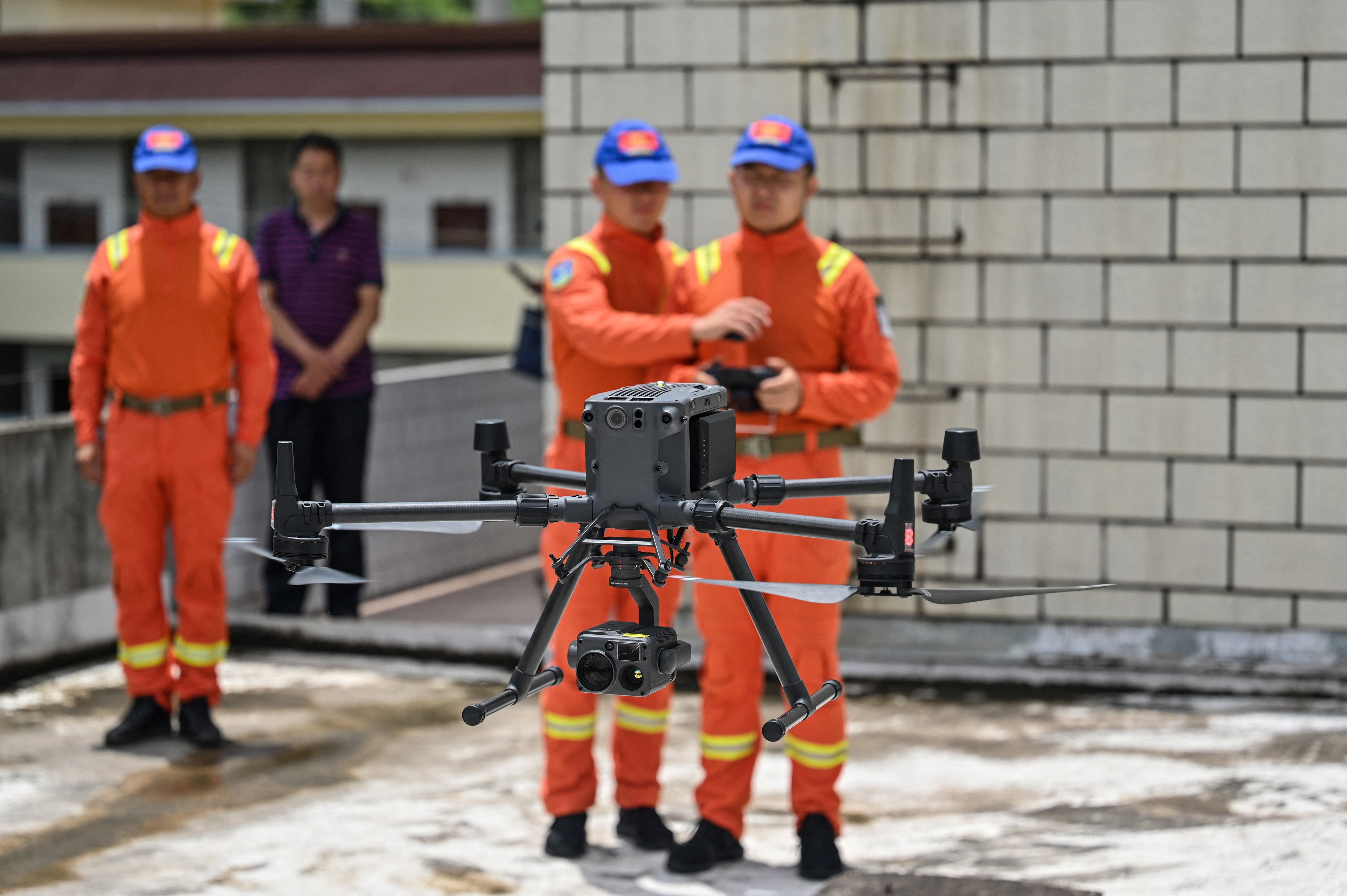 This picture taken on 23 July 2021 shows members of the Yunnan Forest Brigade operating a drone to monitor a herd of migrating wild Asian elephants at the command centre in Daqiao in southwest China’s Yunnan province