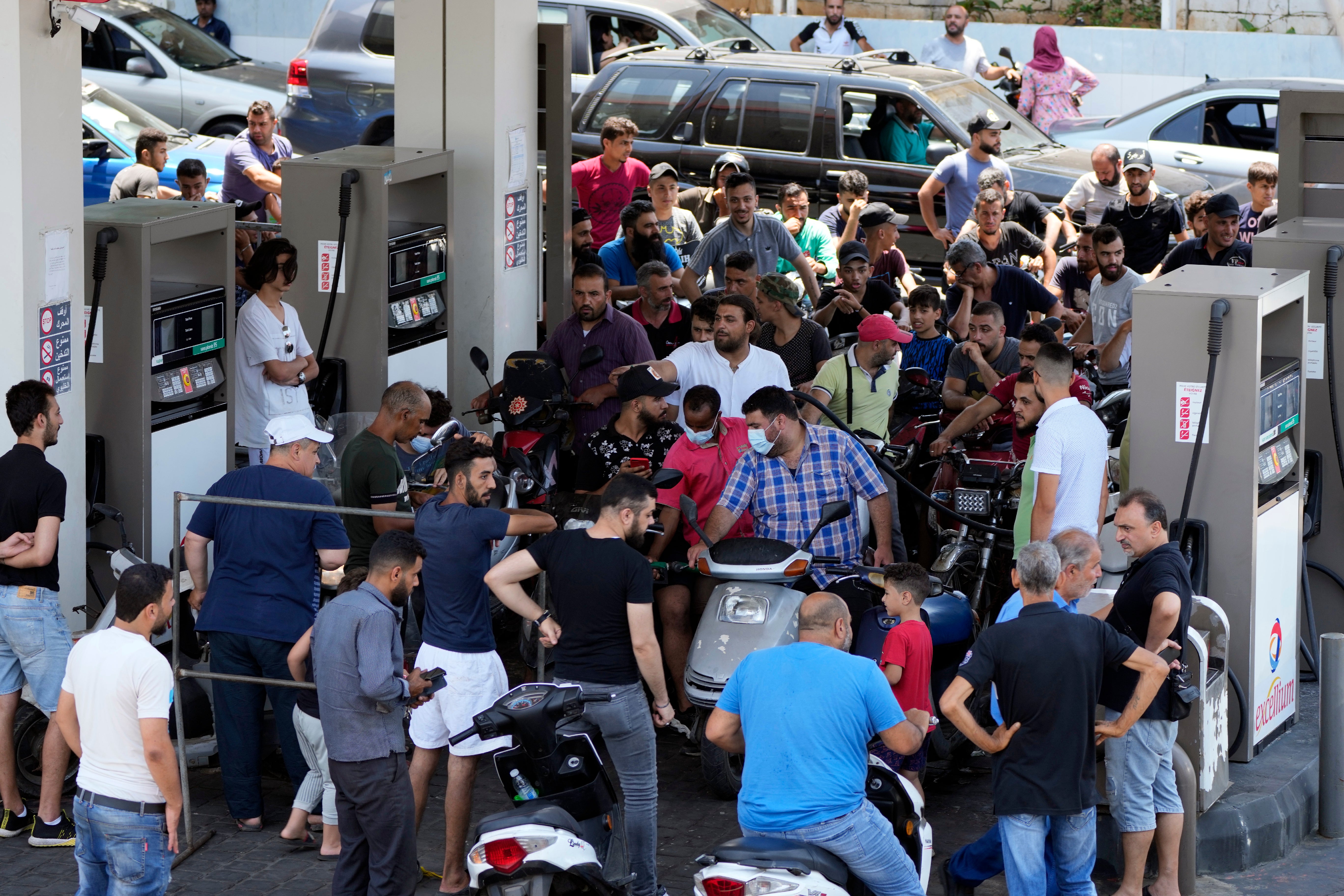 Motorcycle riders wait to get fuel at a petrol station in a southern suburb of Beirut