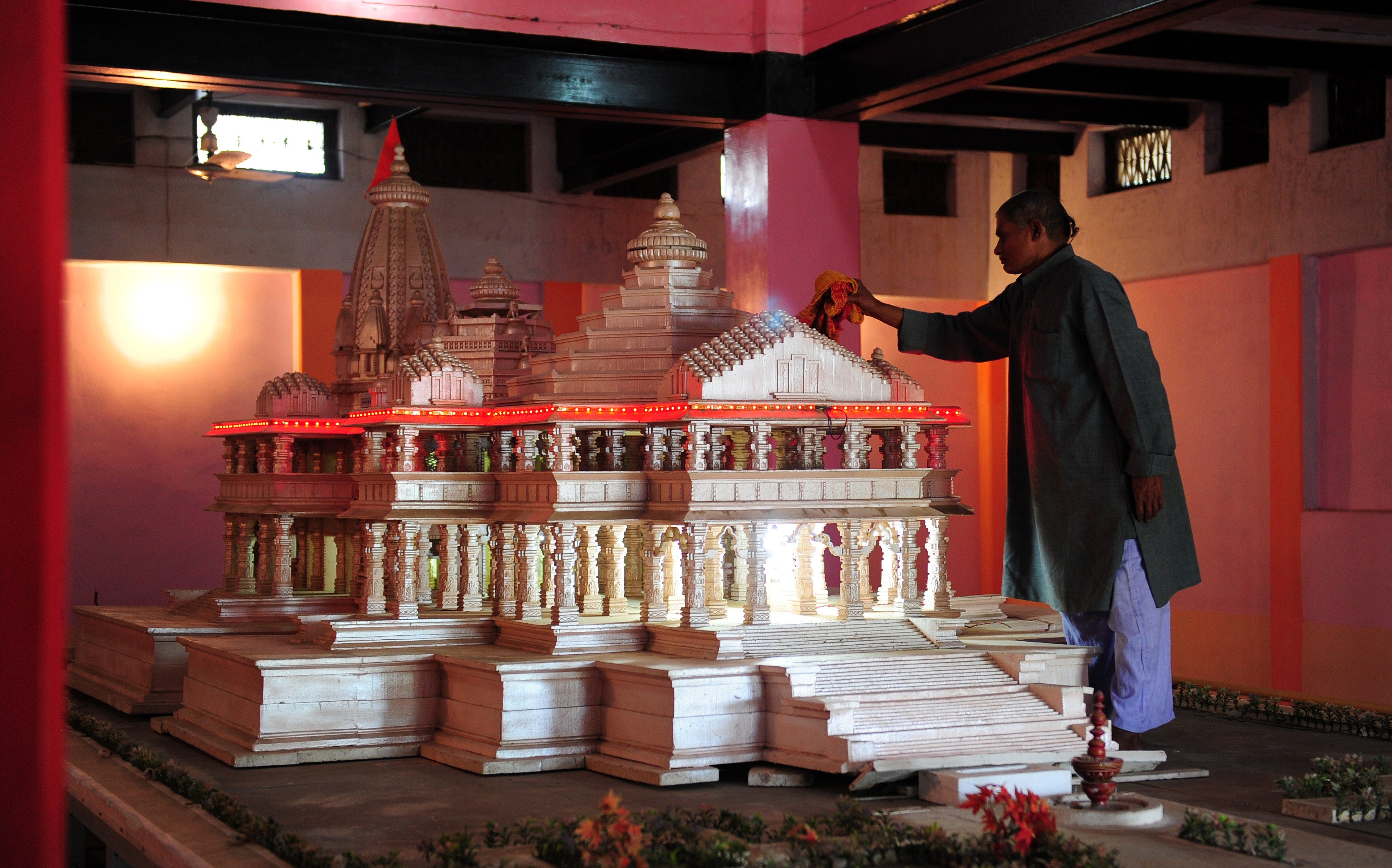 An Indian worker dusts a model of the proposed Hindu Temple in Ayodhya