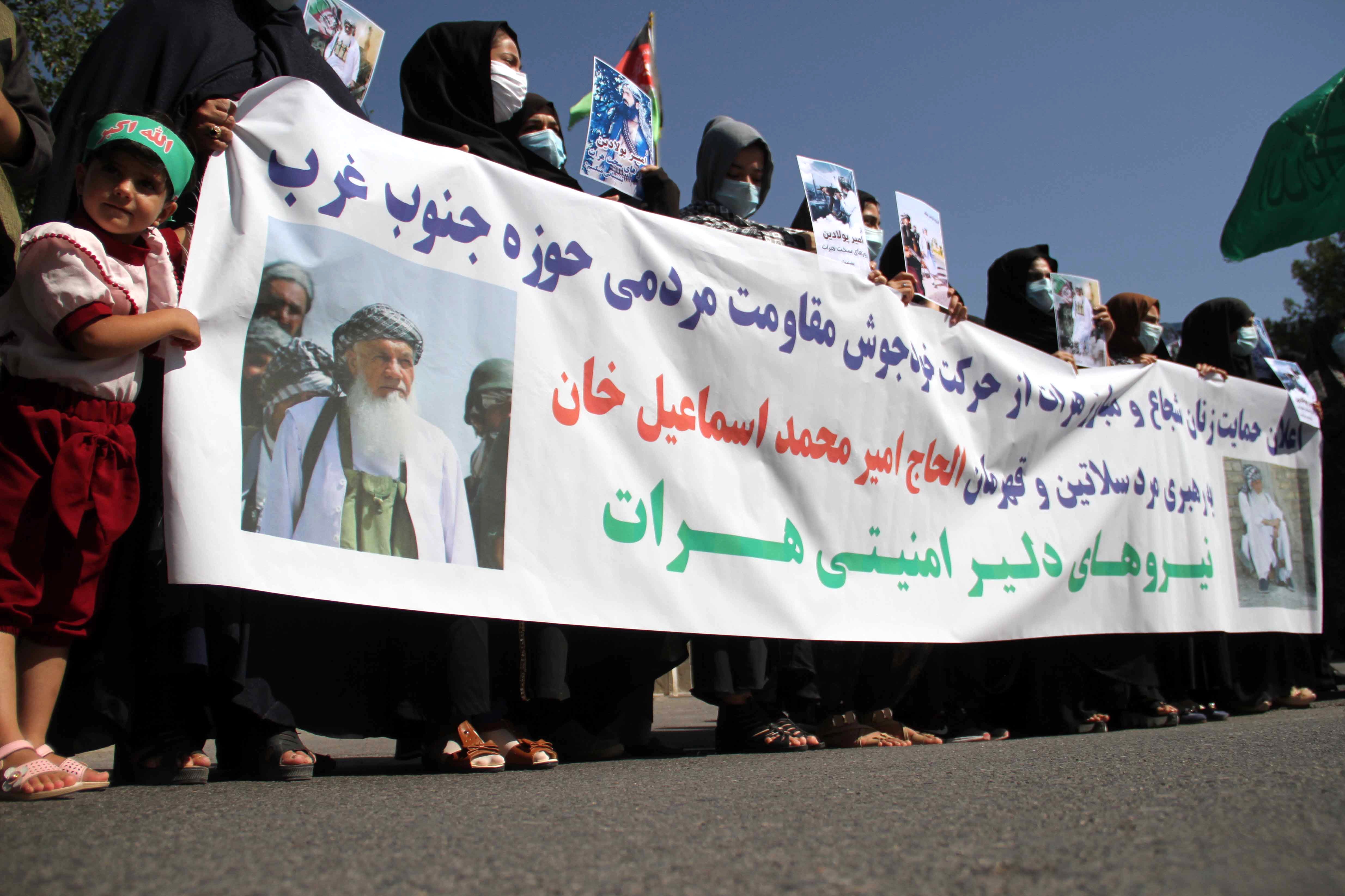 Afghan women hold pictures of former Mujahideen commander Ismail Khan