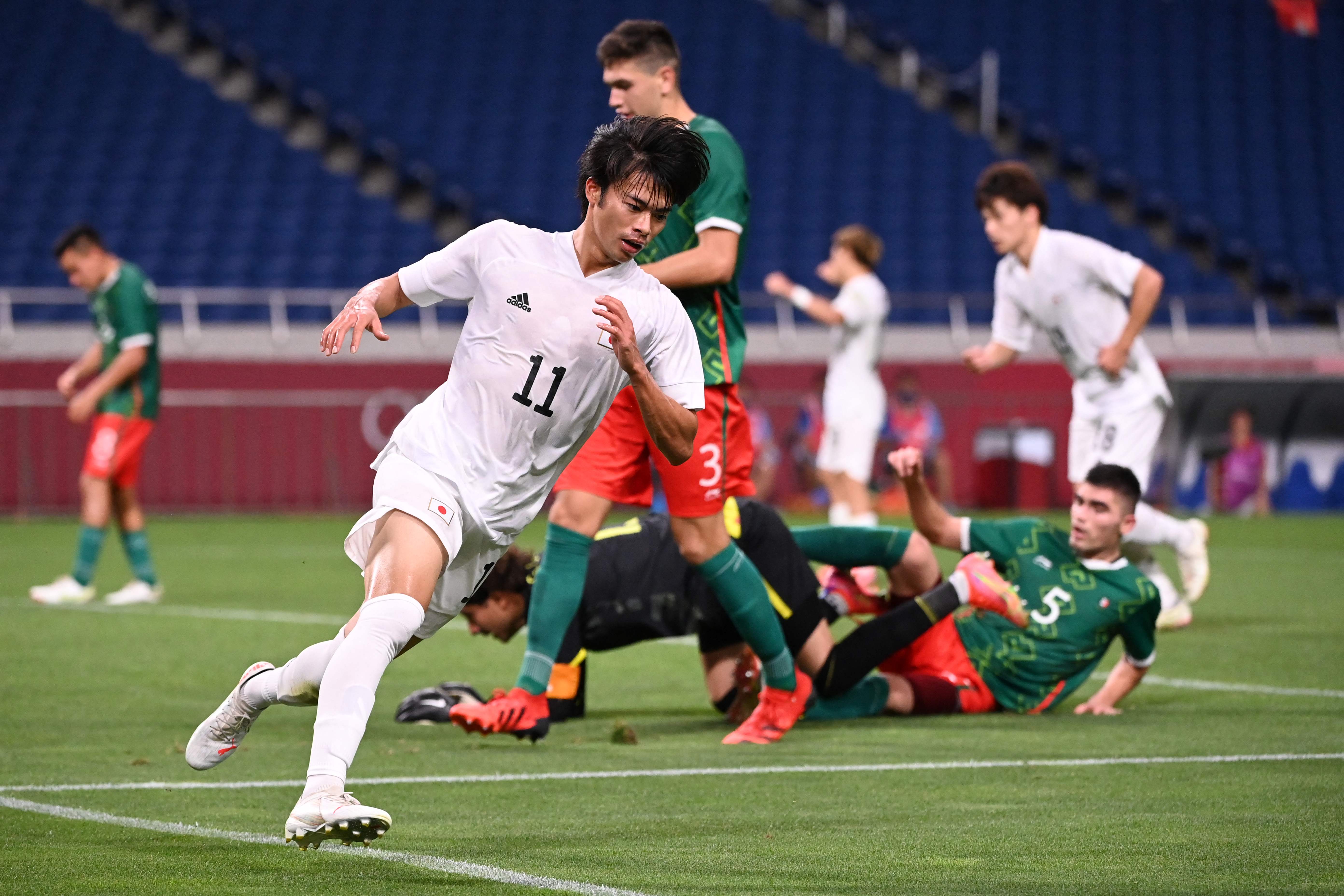 Japan's forward Kaoru Mitoma (C) runs to celebrate after scoring a goal during the Tokyo 2020 Olympic Games men's bronze medal football match