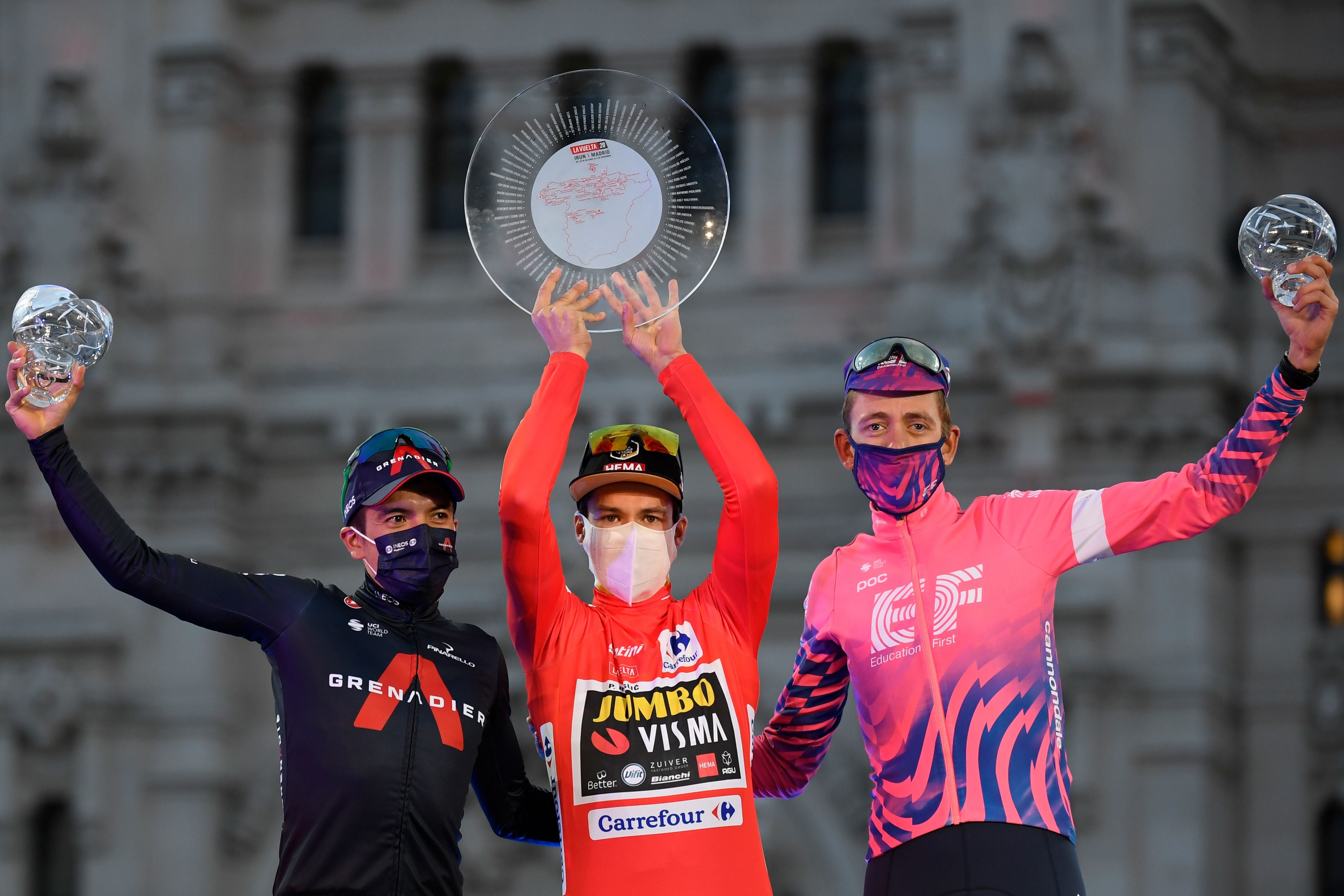 Primoz Roglic, centre, celebrates on the podium with Richard Carapaz, left, and Hugh Carthy after the 18th and final stage of the 2020 Vuelta a Espana