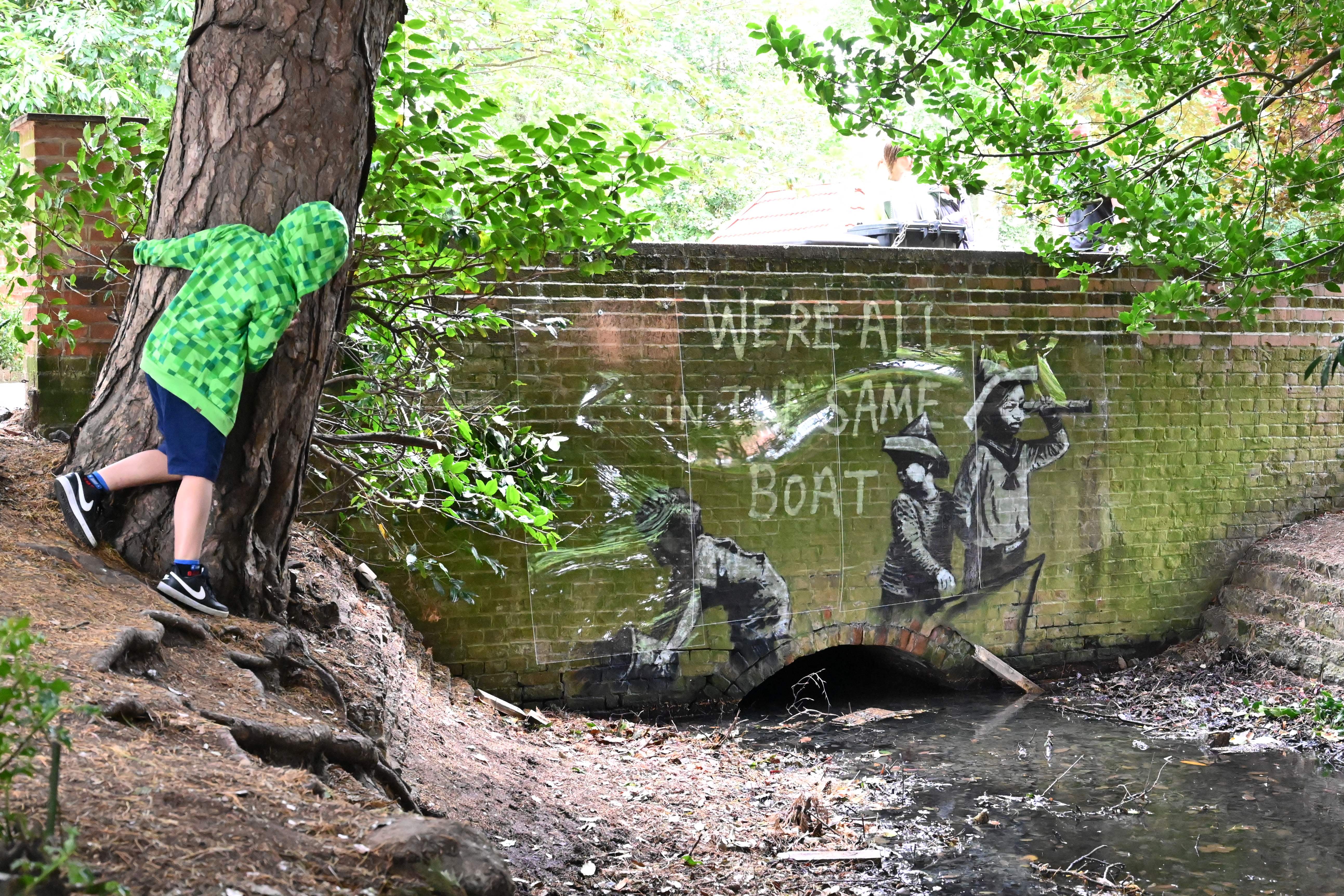 A child inspects the mural in Lowestoft after the metal raft had been removed