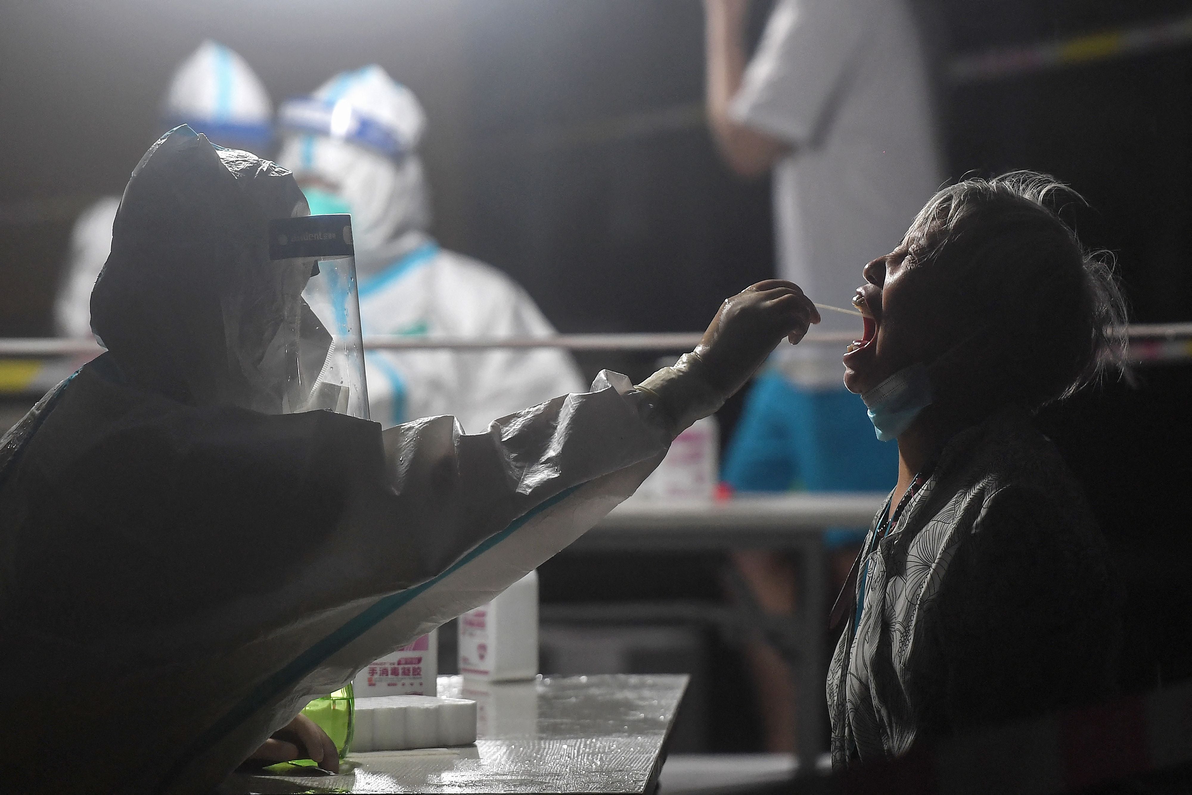 A resident receiving a test for Covid-19 in a residential area of Wuhan