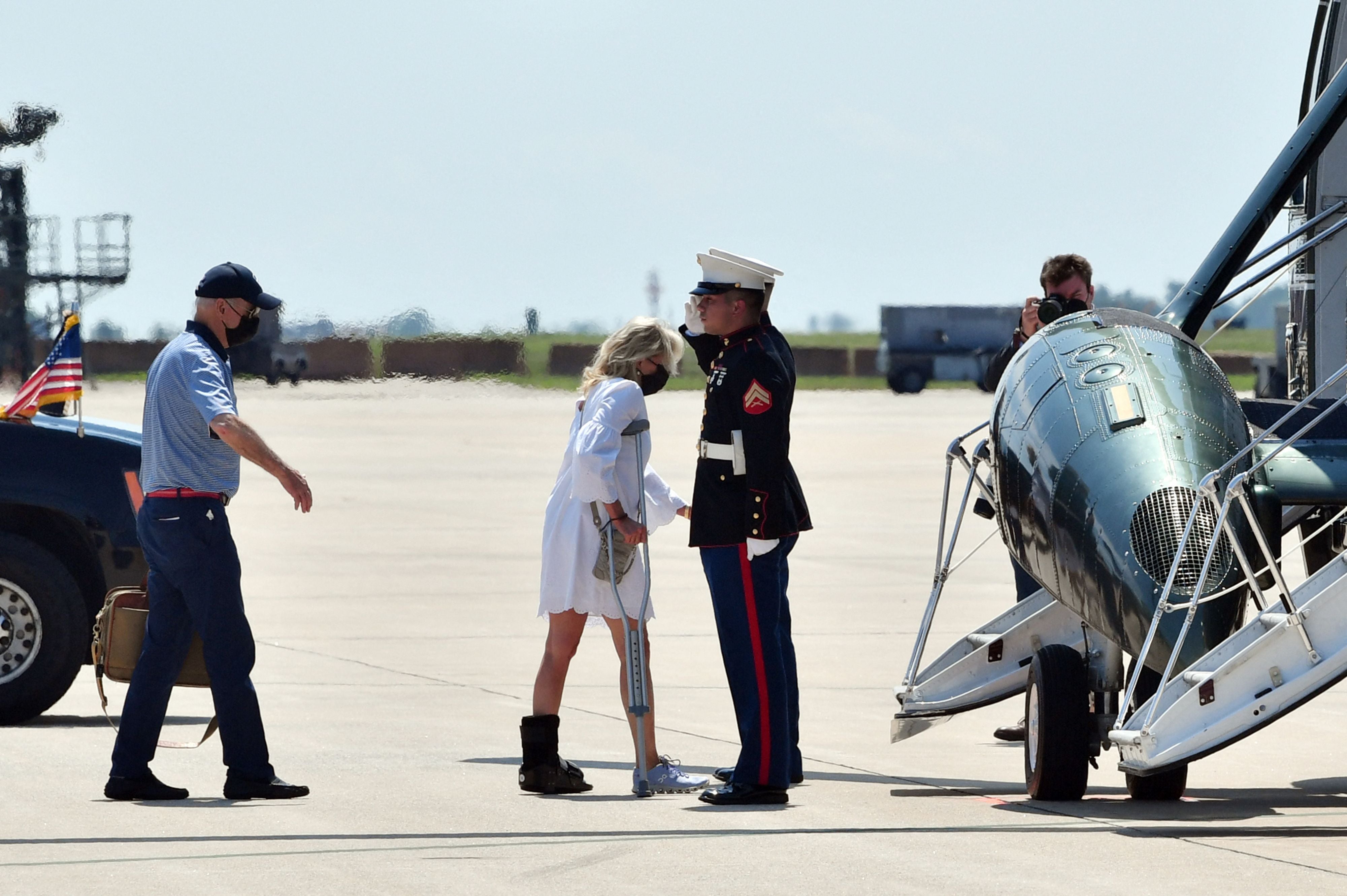 US President Joe Biden (L) and First Lady Jill Biden (C) board Marine One at Delaware Air National Guard in New Castle, Delaware, on August 13, 2021, as they travel to Camp David, Maryland.