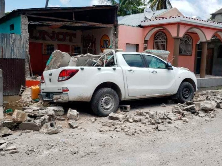 A truck is covered by parts of a wall that fell on it during an earthquake in Les Cayes, Haiti