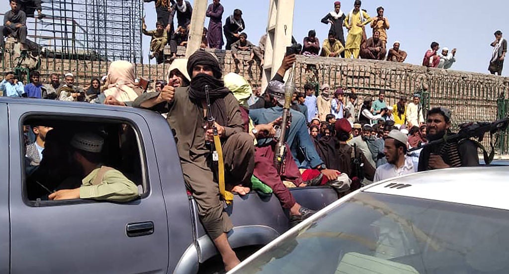 Taliban fighters sit on a vehicle on the street in Jalalabad province on 15 August