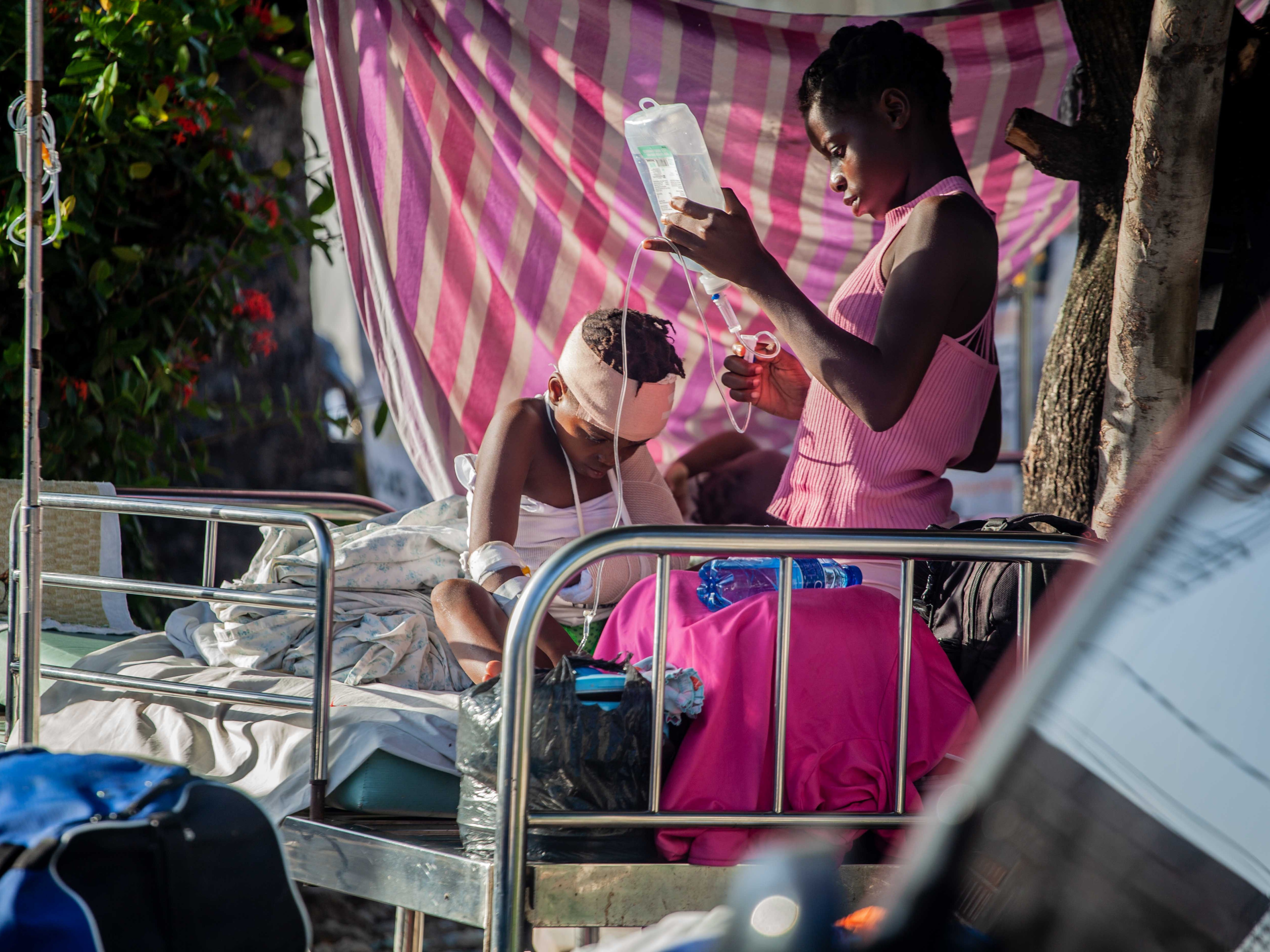 A boy is tended to outside Les Cayes General Hospital after a 7.2-magnitude earthquake on 15 August 2021 in Les Cayes, Haiti