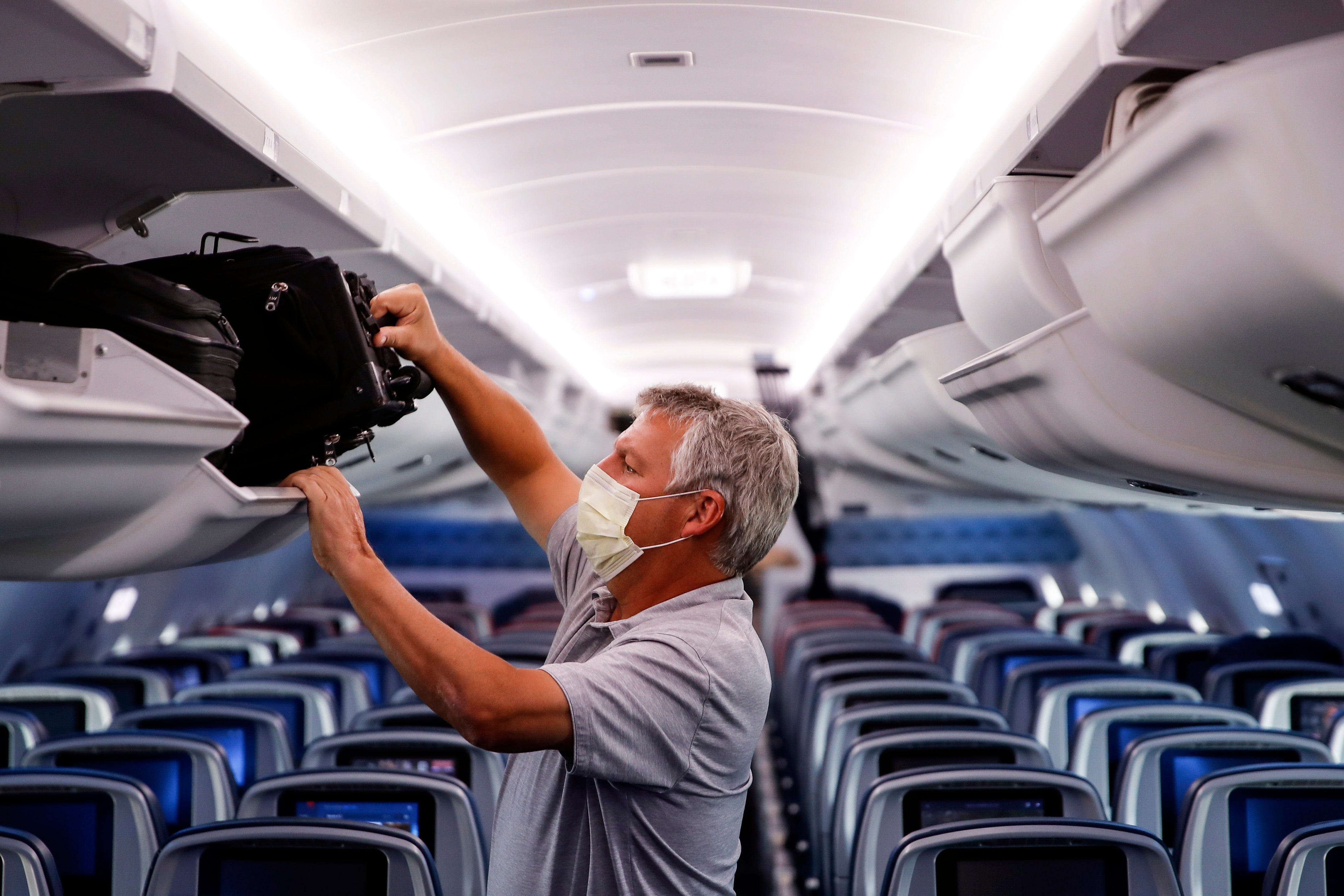 File: A passenger wears personal protective equipment on a Delta Airlines flight