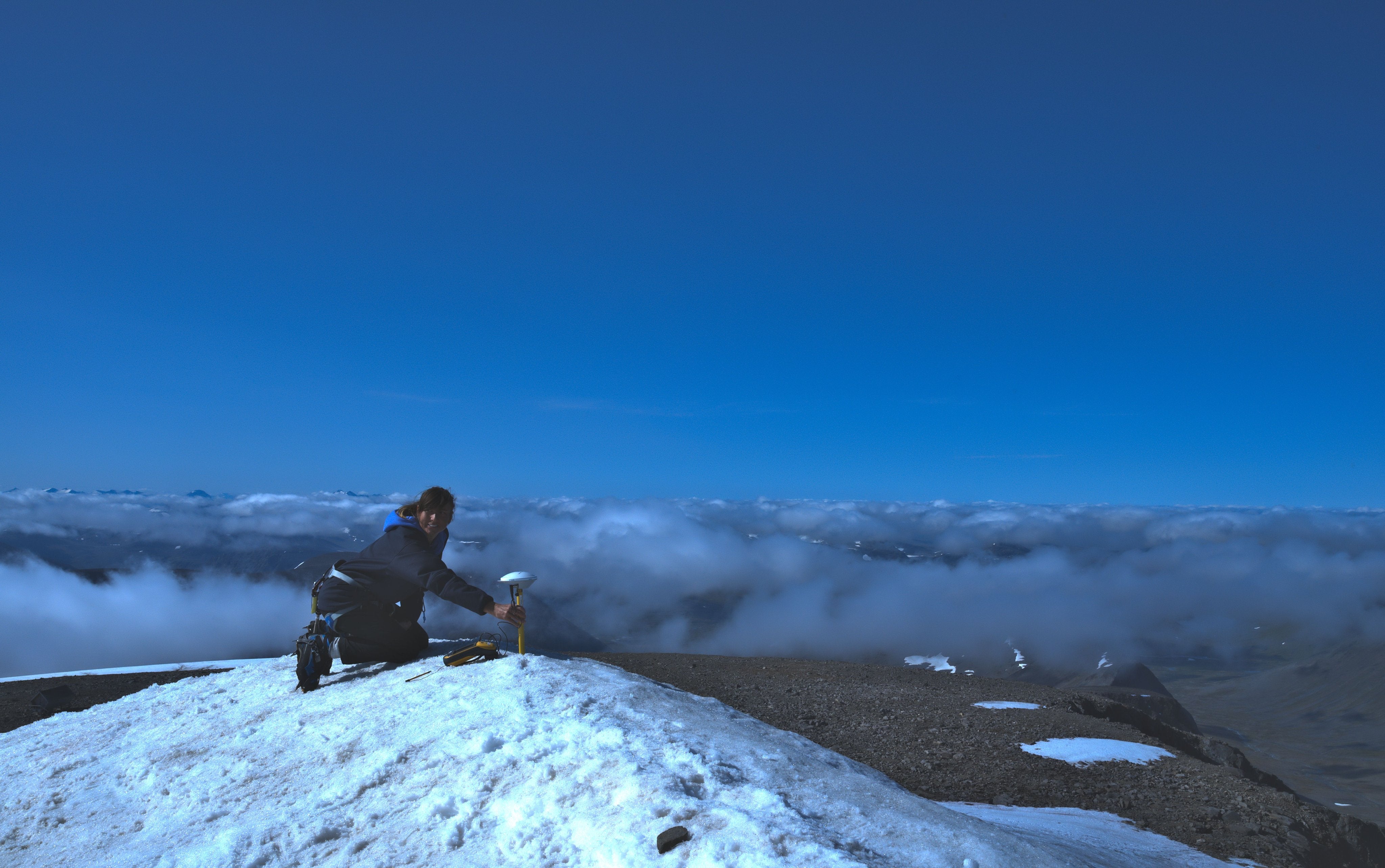 Tarfala station manager Annika Granebeck measures the height at the top of Kebnekaise on 14 August 2021