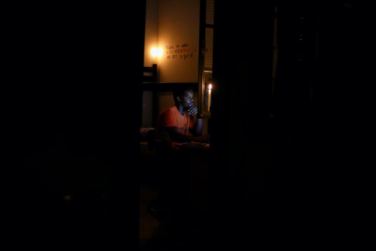 Felipe studies on his laptop during a power cut at the student residence in Nitero where he lives temporarily