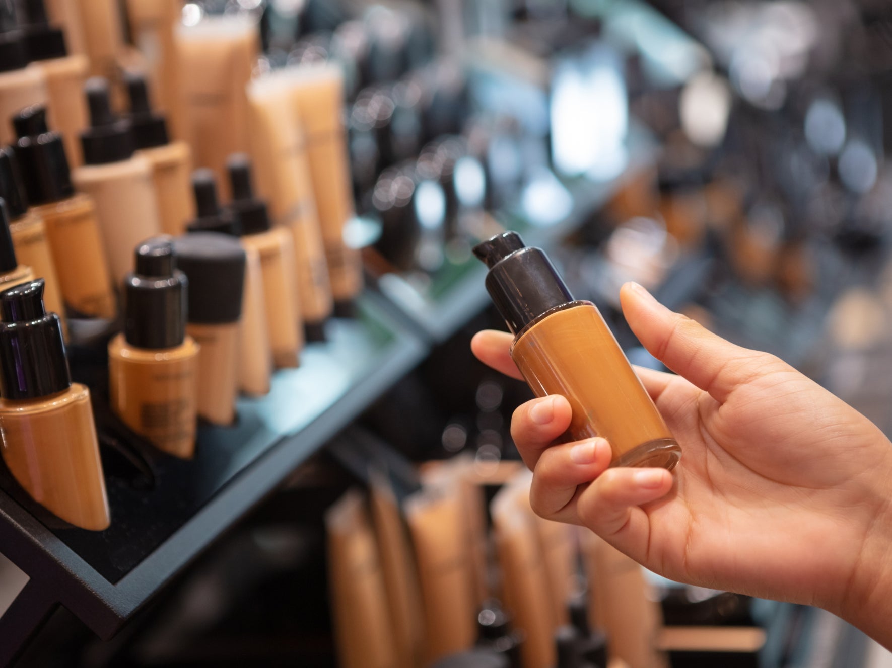 A person chooses foundation at a makeup counter