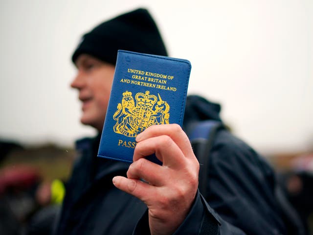 <p>A Vote Leave supporter holds up a blue UK passport on the ‘March to Leave’ walk</p>