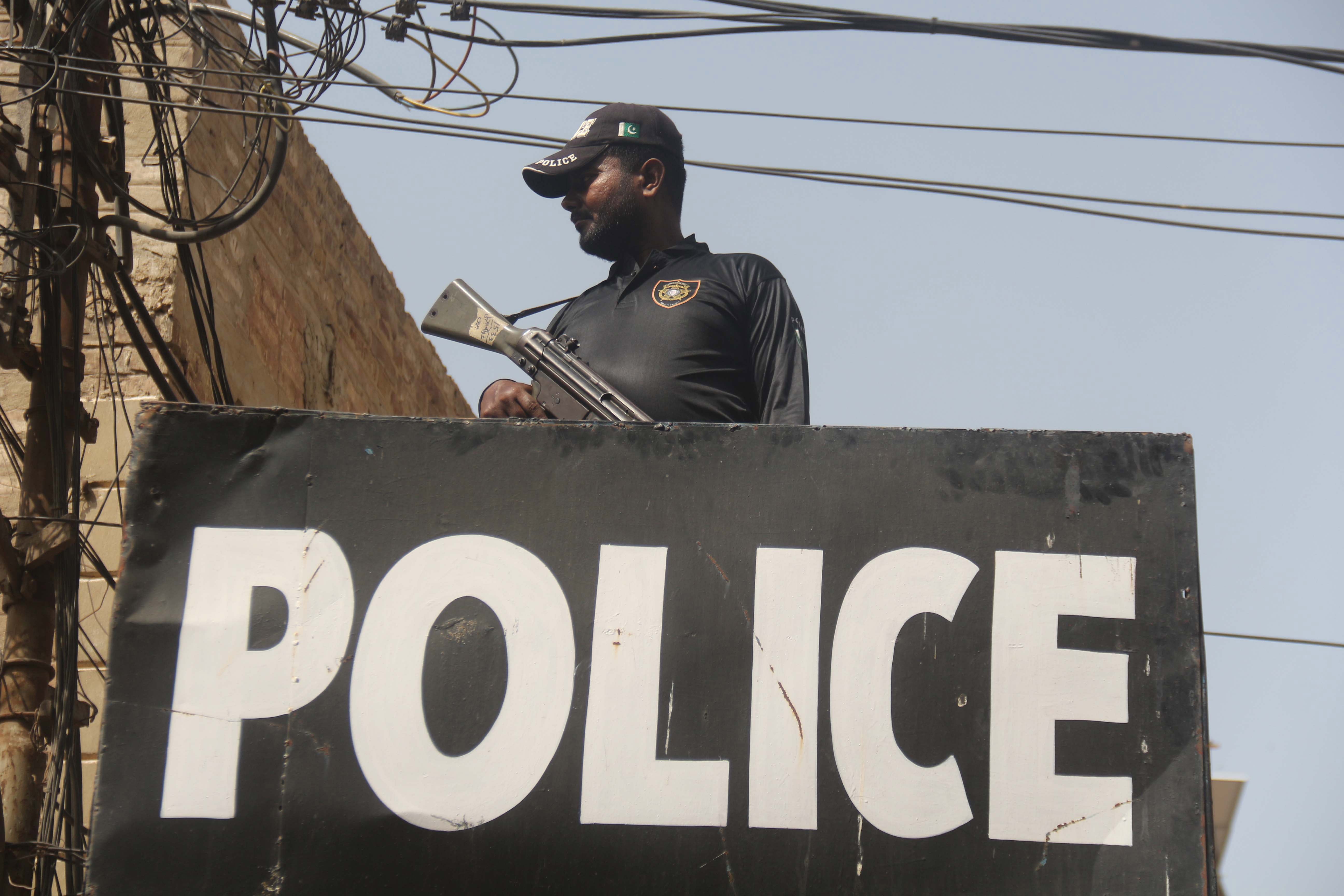 A Pakistani security official stands guard during an Ashura Day procession, the climax of the holy month of Muharram, in Hyderabad, on 19 August 2021