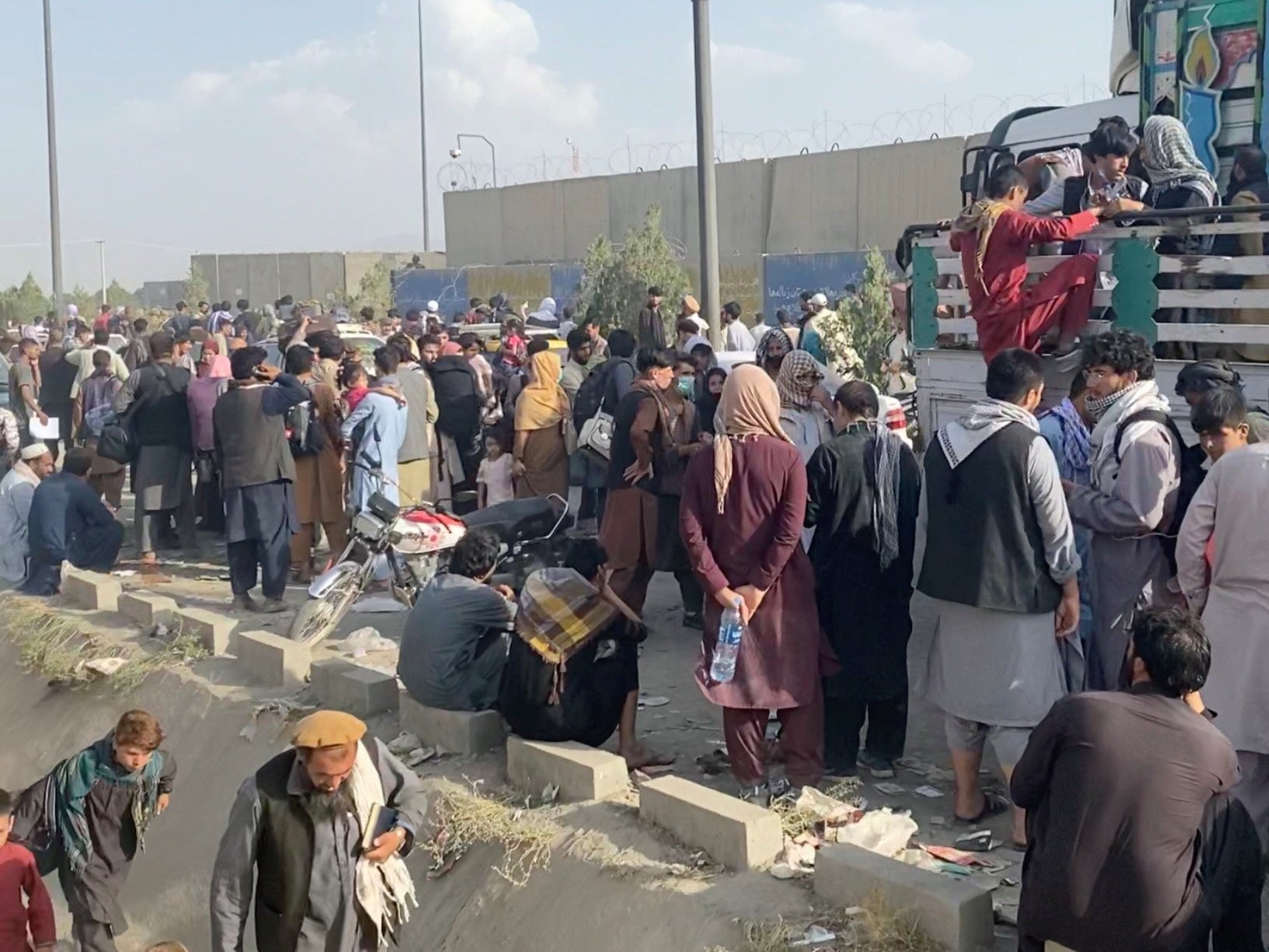 Hundreds of fleeing Afghans wait outside Kabul airport on Thursday