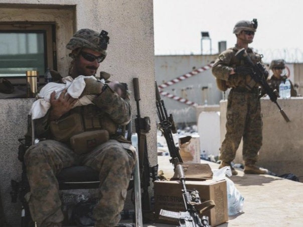 A photo of a US marine holding a child during the evacuation from Afghanistan