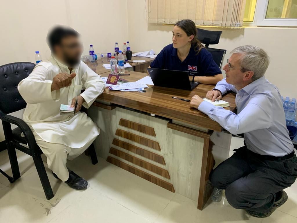 Britain’s Ambassador to Afghanistan Laurie Bristow speaks with a man as officials facilitate the UK evacuation effort in Kabul