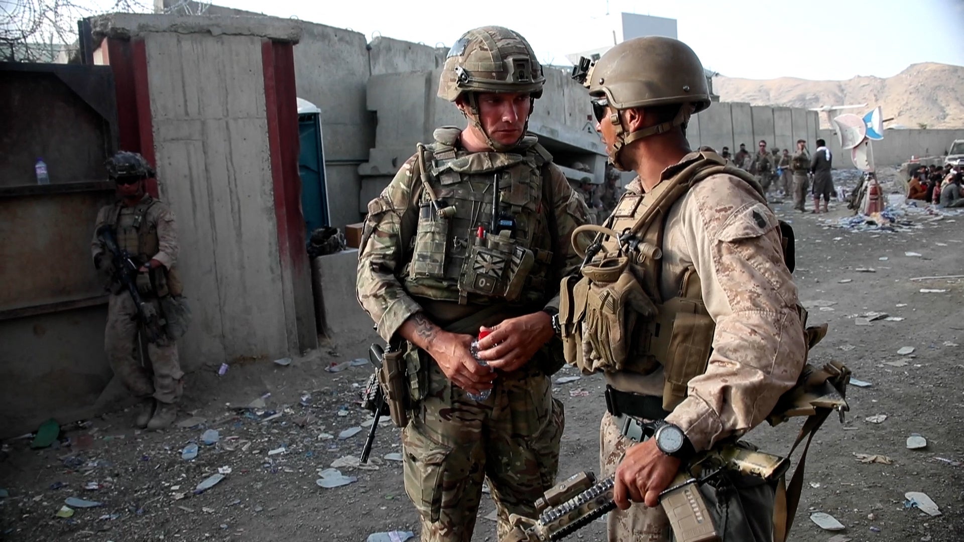 A handout picture released by the British Ministry of Defence (MOD) shows a British soldier (L) and a member of the US Armed Forcesin conversation while working at Kabul Airport