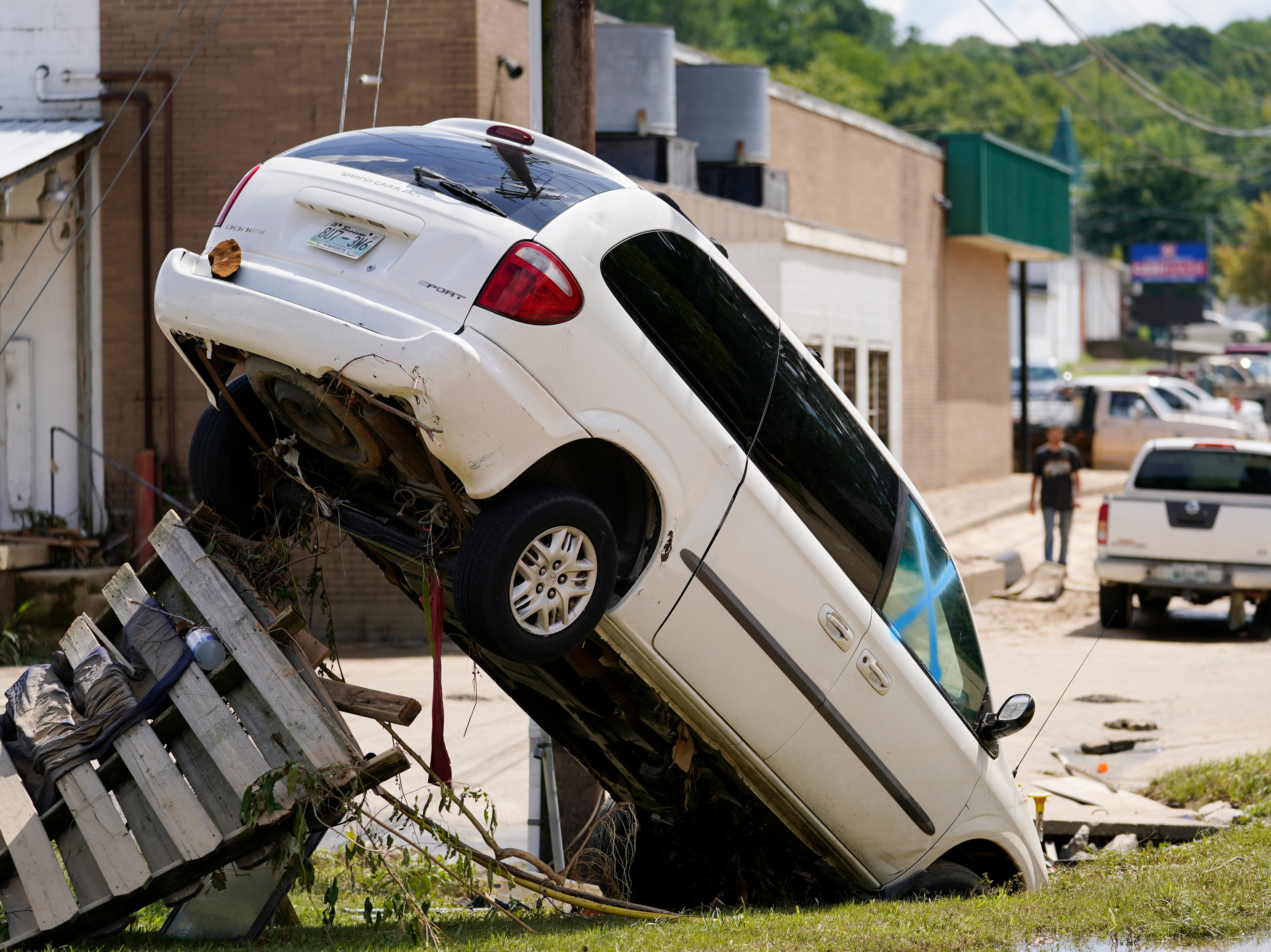 A car flipped upside-down and supporterd by a utility pole in Waverly, Tennessee, the morning after the devastating flooding