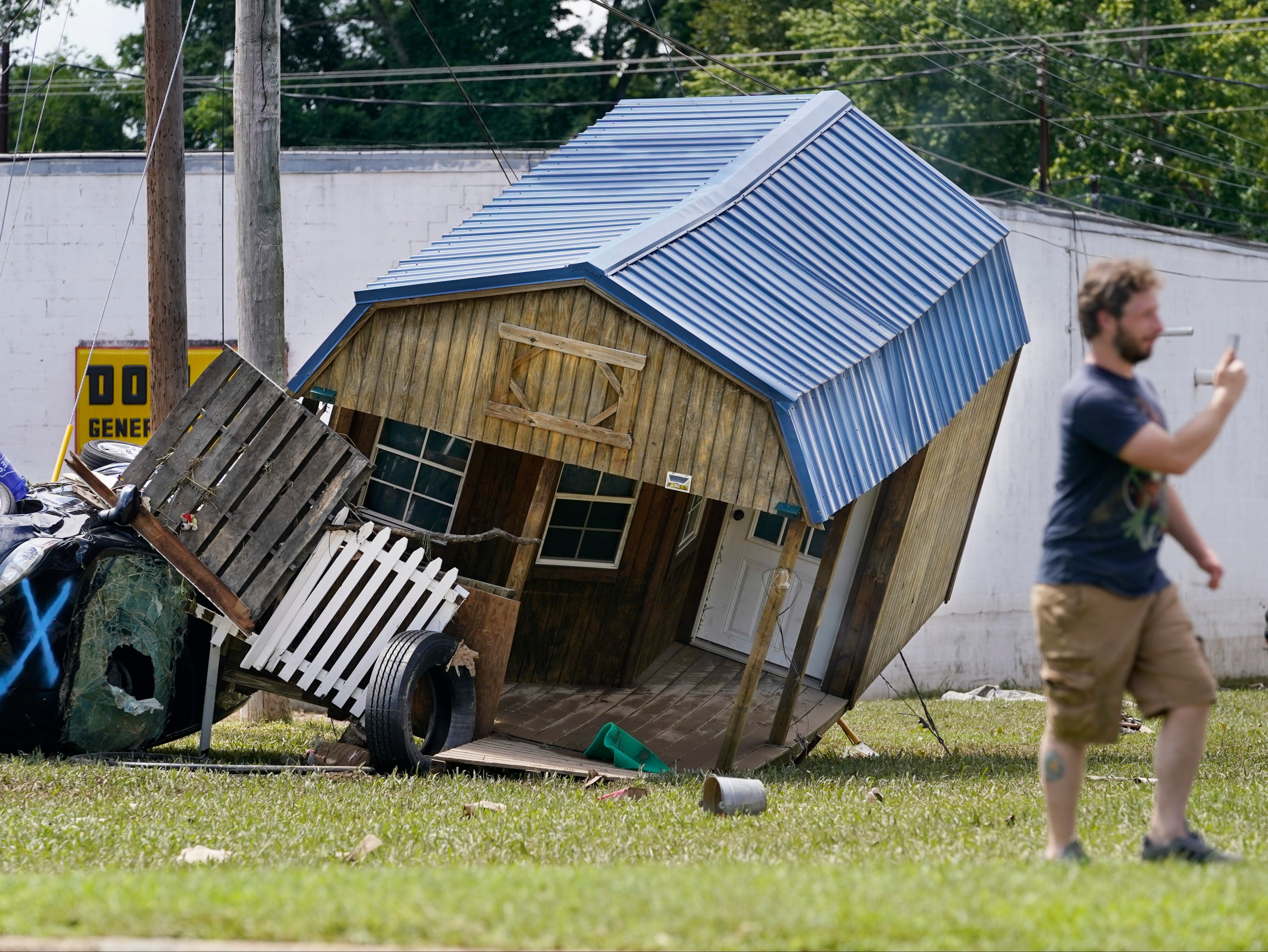 A car and mangled utility building lean against one another in Waverly, Tennesee, after the storm