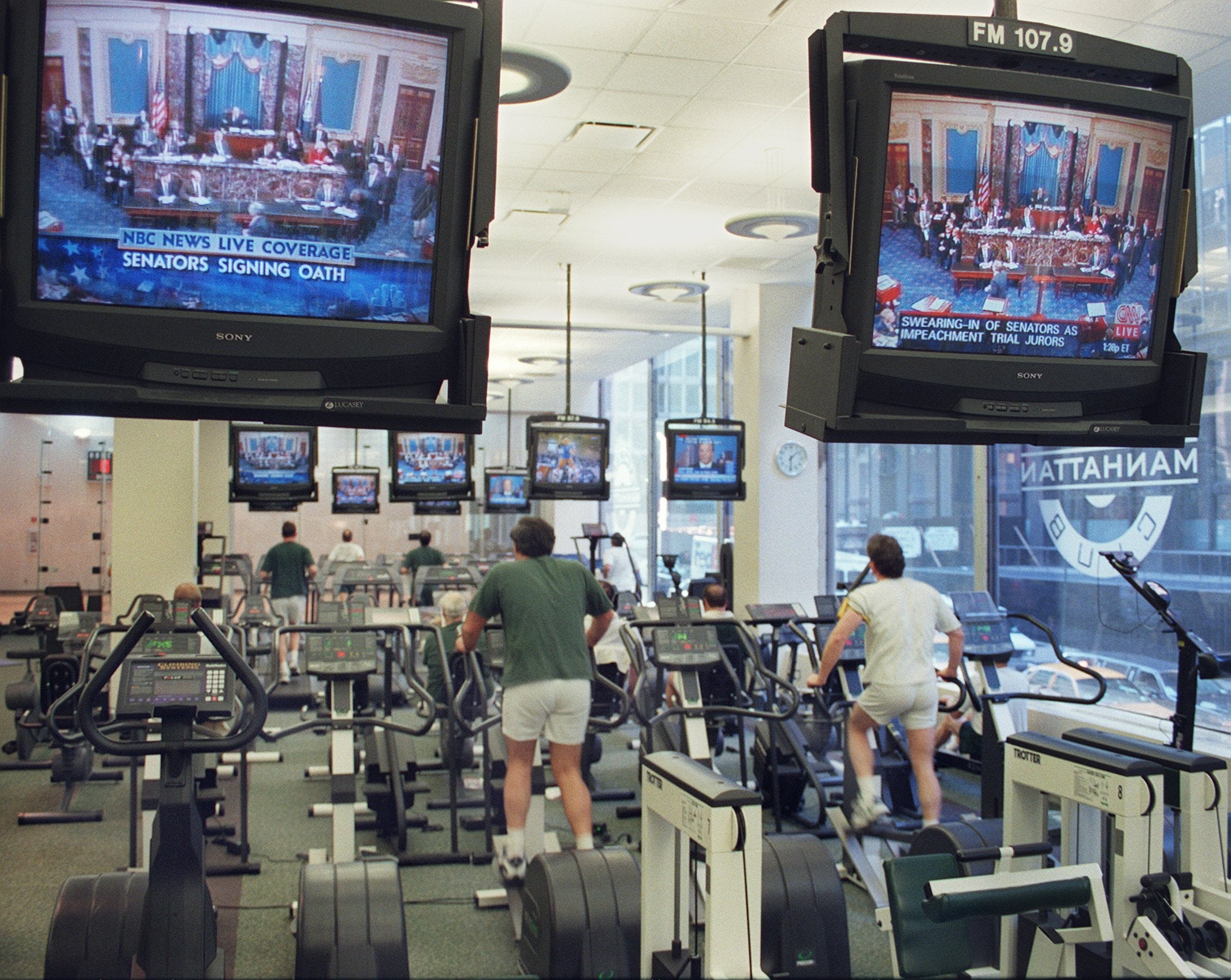 A group of people exercise on 7 January 1999 at the Manhattan Athletic Club in New York as they watch a live television broadcast of the impeachment trial of US President Bill Clinton