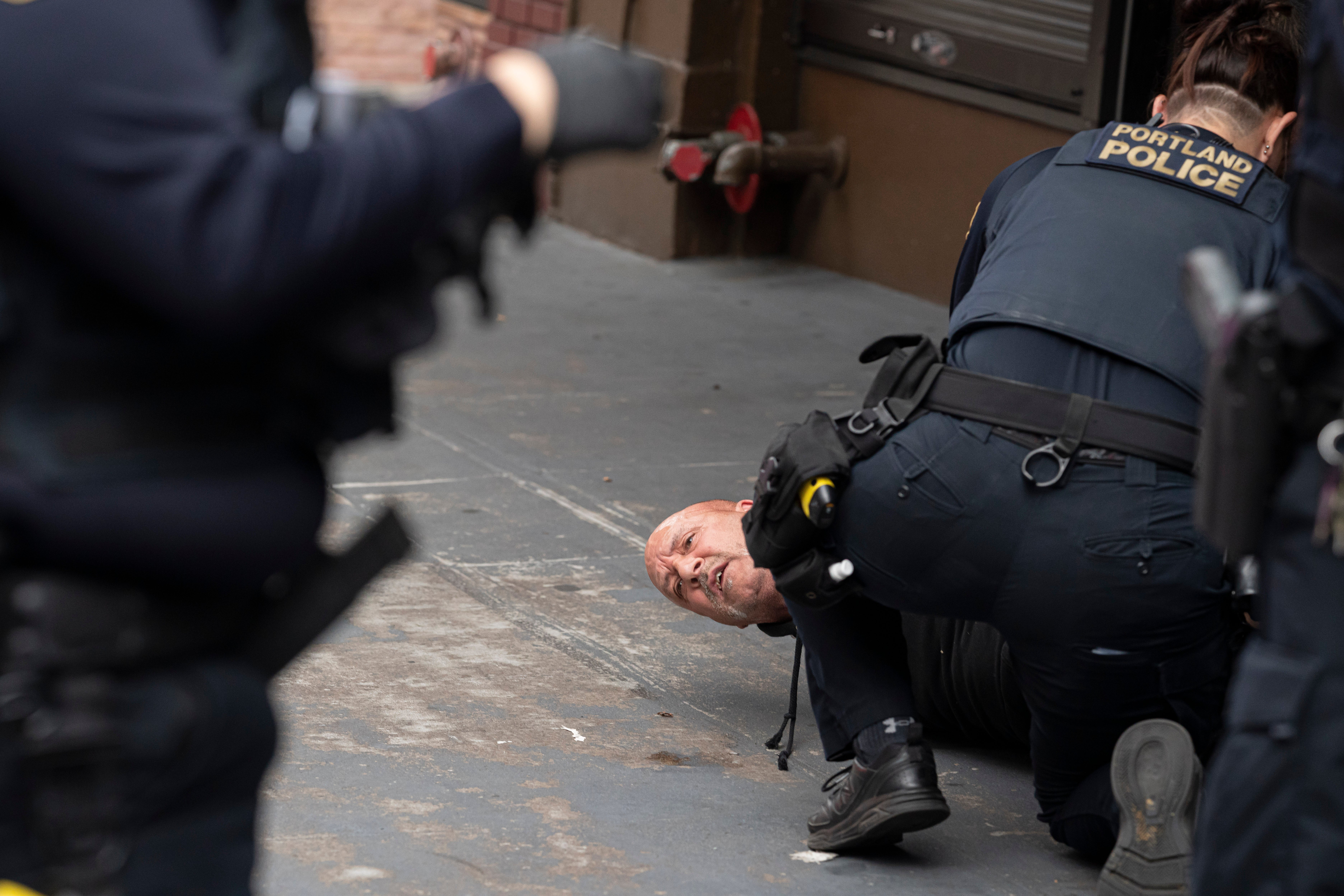 Portland police arrest a man who allegedly exchanged gunfire with two other men near a rally held by the far-right group Proud Boys on August 22, 2021 in Portland, Oregon. A large left-wing crowd gathered in downtown to counter a planned far-right, Proud Boy rally.