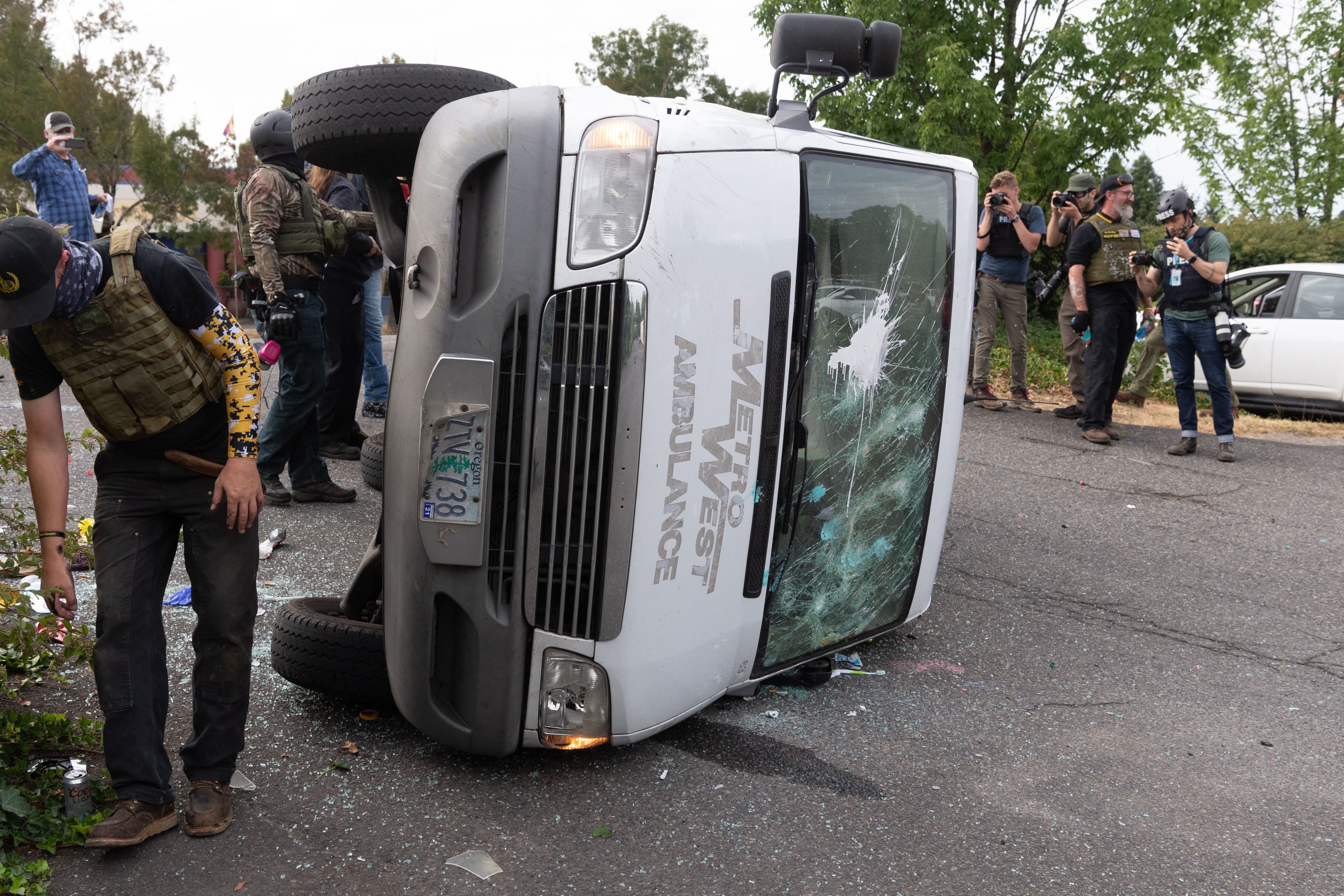 A flipped-over van lies in a parking lot after an altercation between members of the Proud Boys and anti-fascist activists following a far-right rally on August 22, 2021 in Portland, Oregon. - Far-right groups, including the Proud Boys held a rally in Portland on the anniversary of a violent altercation with anti-fascist activist a year earlier.