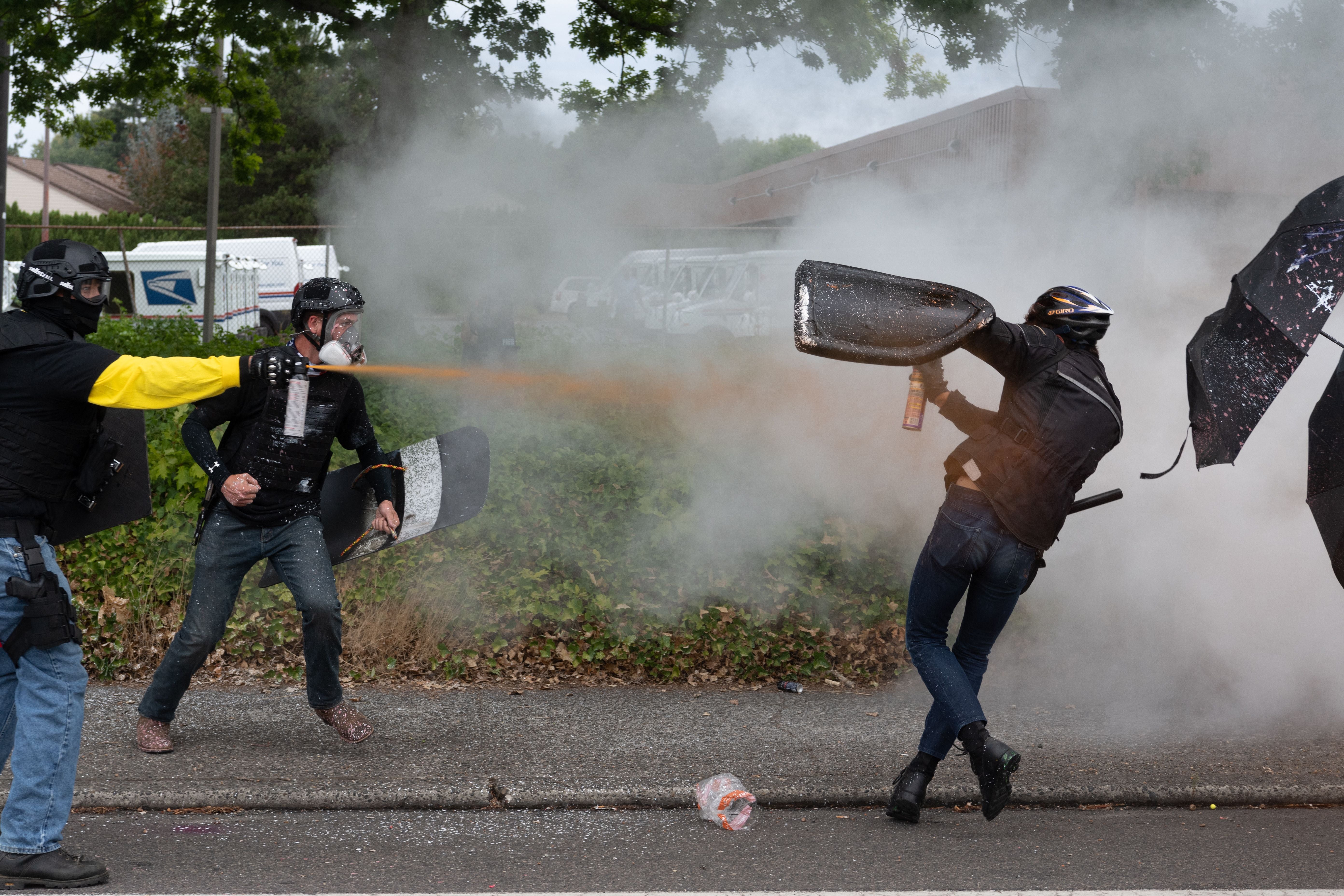 Members of the Proud Boys (L) clash with anti-fascist activists following a far-right rally on August 22, 2021 in Portland, Oregon. - Far-right groups, including the Proud Boys held a rally in Portland on the anniversary of a violent altercation with anti-fascist activist a year earlier.