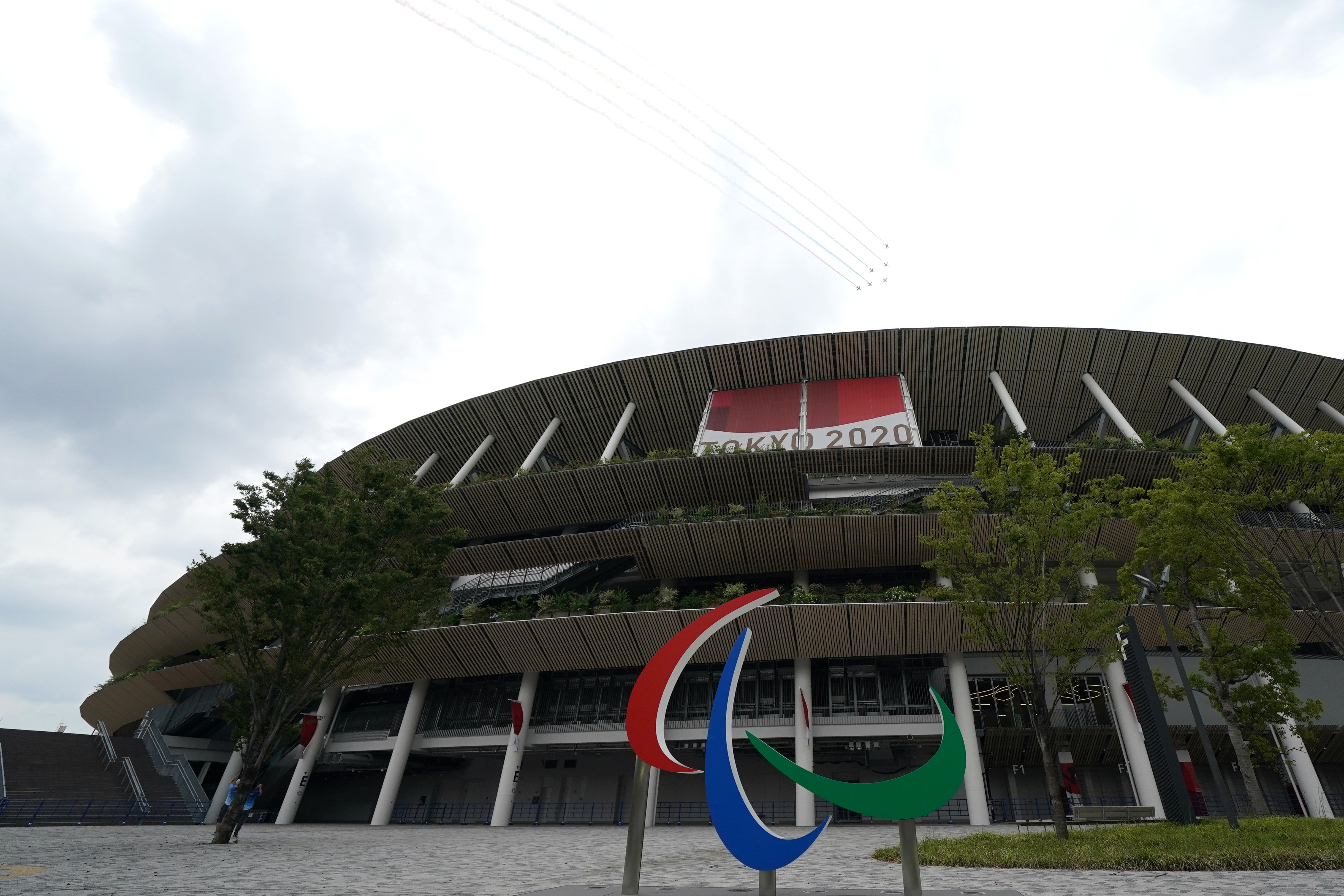 Japan’s Air Self-Defense Force Blue Impulse acrobatic team flies over the National Stadium