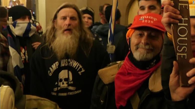 Robert Keith Packer, left, wearing a ‘Camp Auschwitz’ sweatshit during the Capitol riot