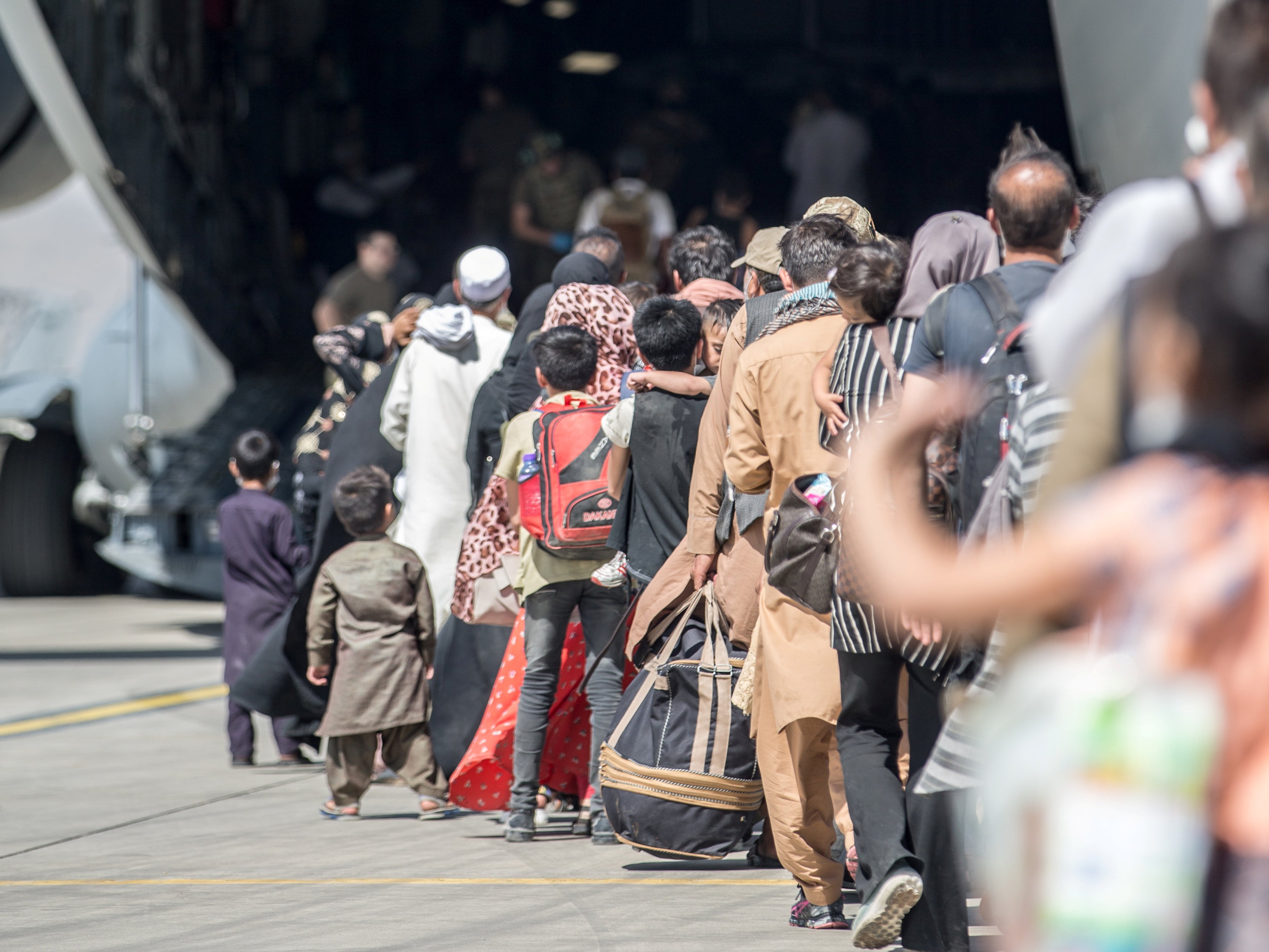 Families board a US flight at Hamid Karzai International Airport in Kabul