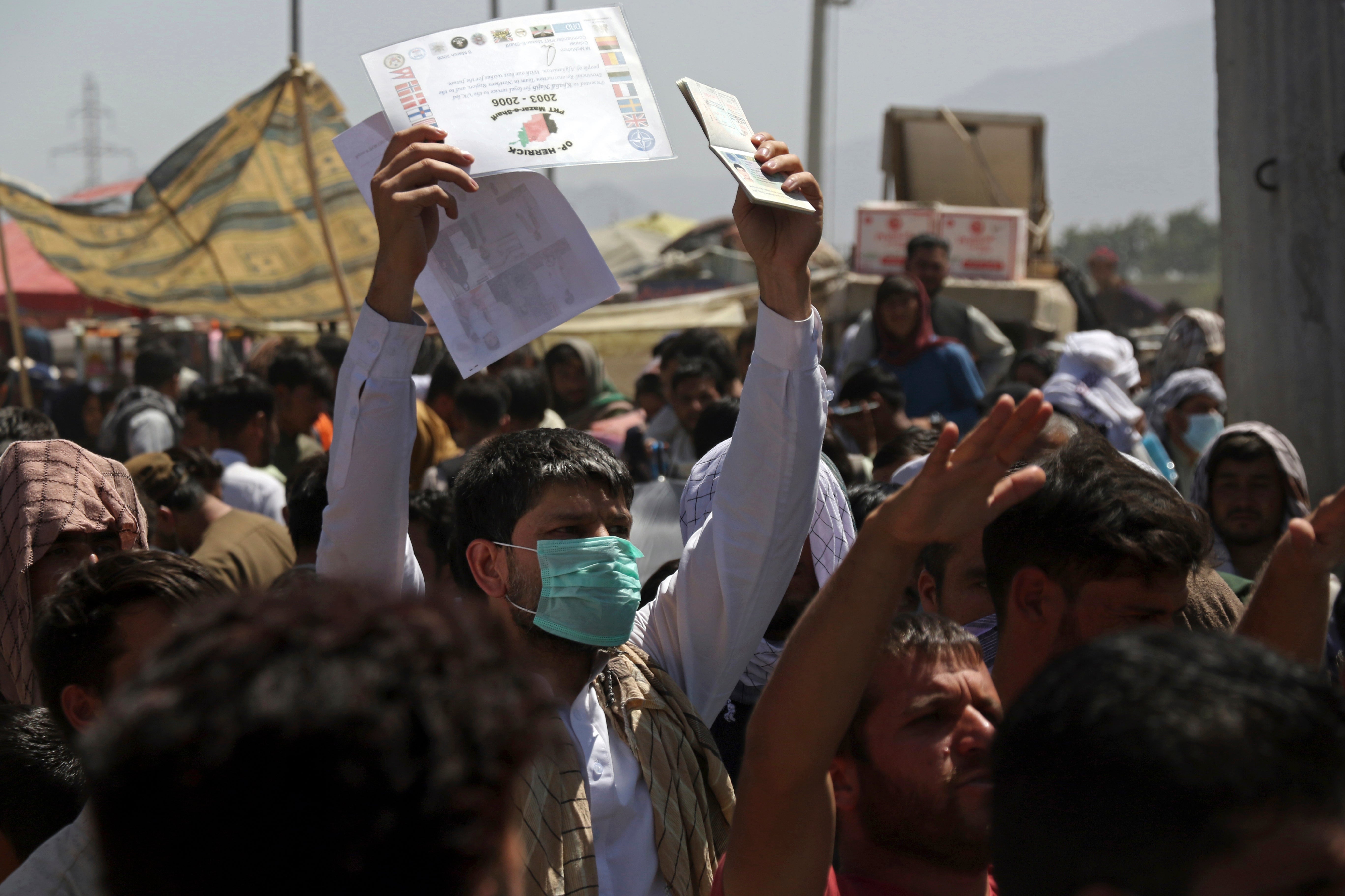 Hundreds of people gather near an evacuation control checkpoint on the perimeter of Kabul airport on Thursday