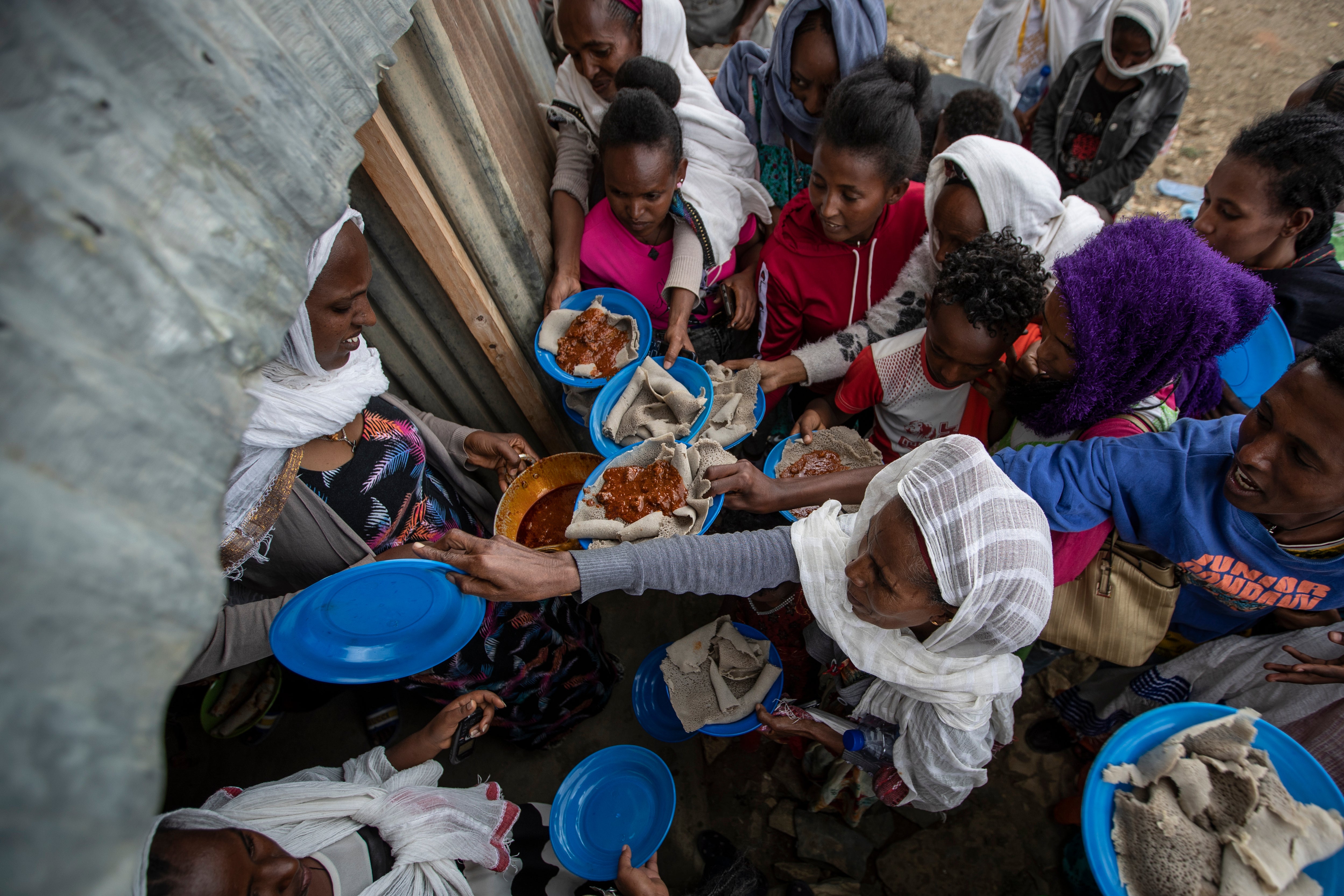 Displaced Tigrayans line up to receive food donated by local residents at a reception centre for the internally displaced in Mekele, in the Tigray region of northern Ethiopia