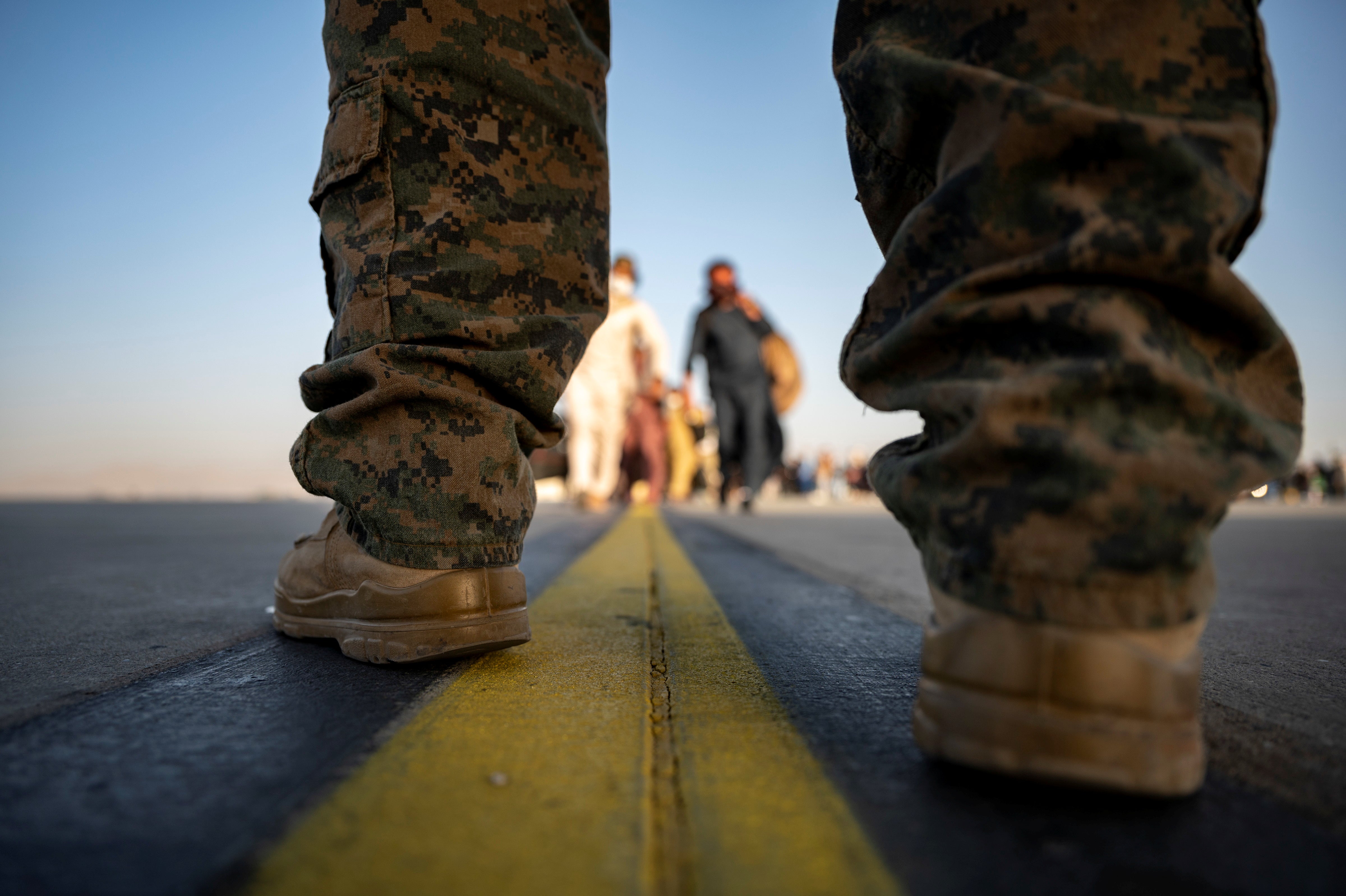 A US Marine provides security for qualified evacuees boarding a US Air Force C-17 Globemaster III in support of the noncombatant evacuation operation at Hamid Karzai International Airport in Kabul