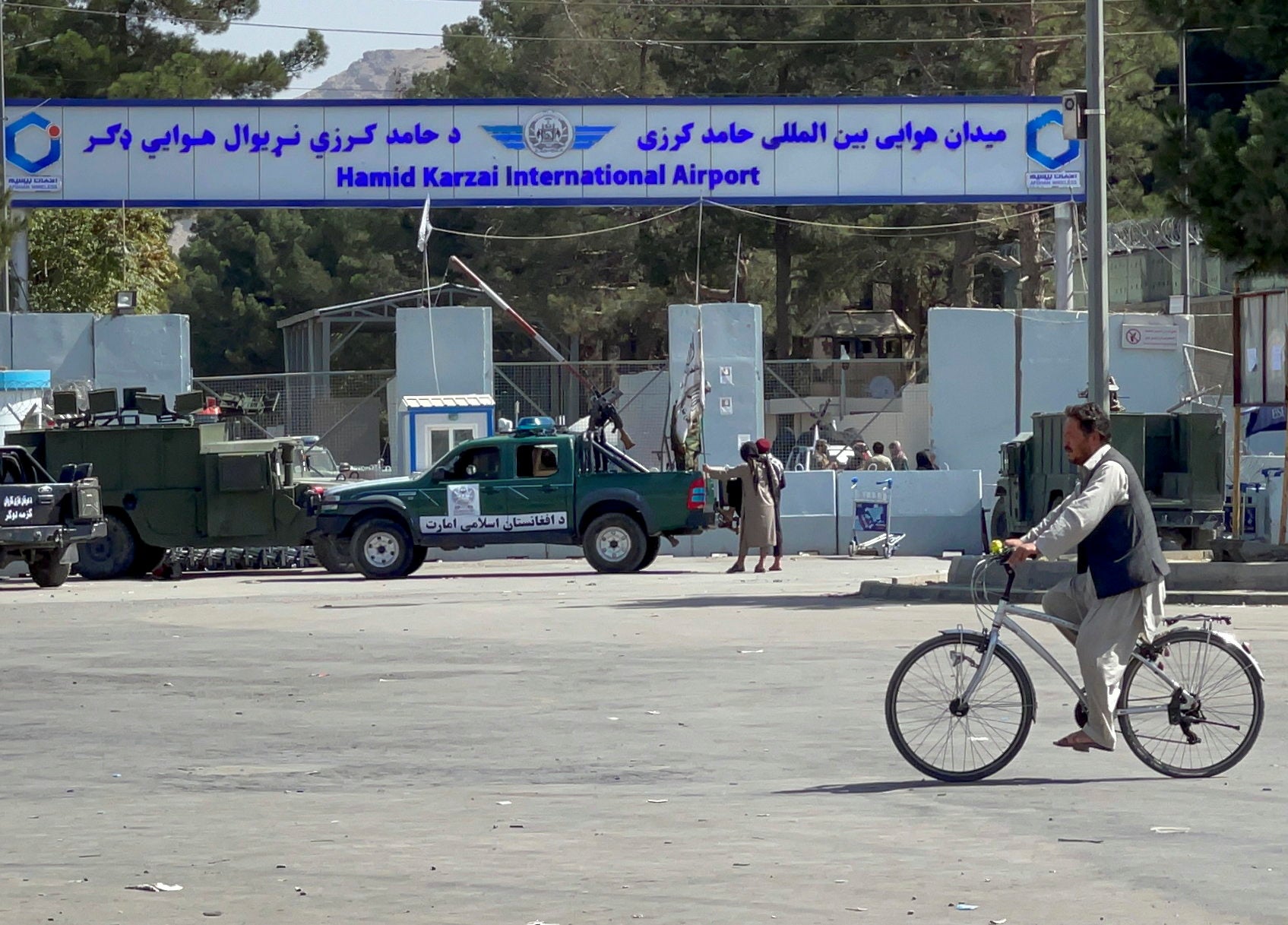 Taliban stand at the entrance gate of Hamid Karzai International airport on Friday