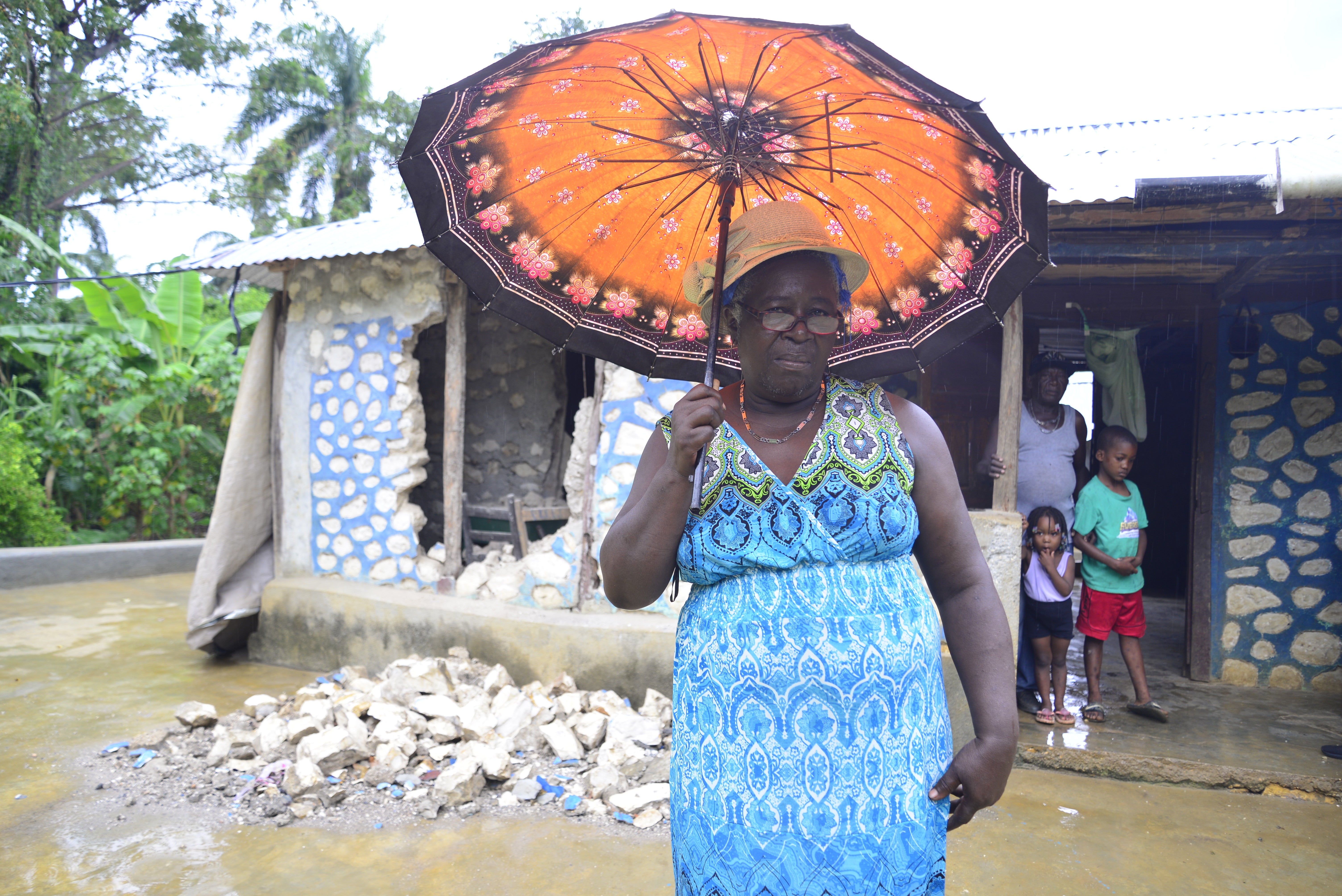 Estabelle stands in front of what is left of her home