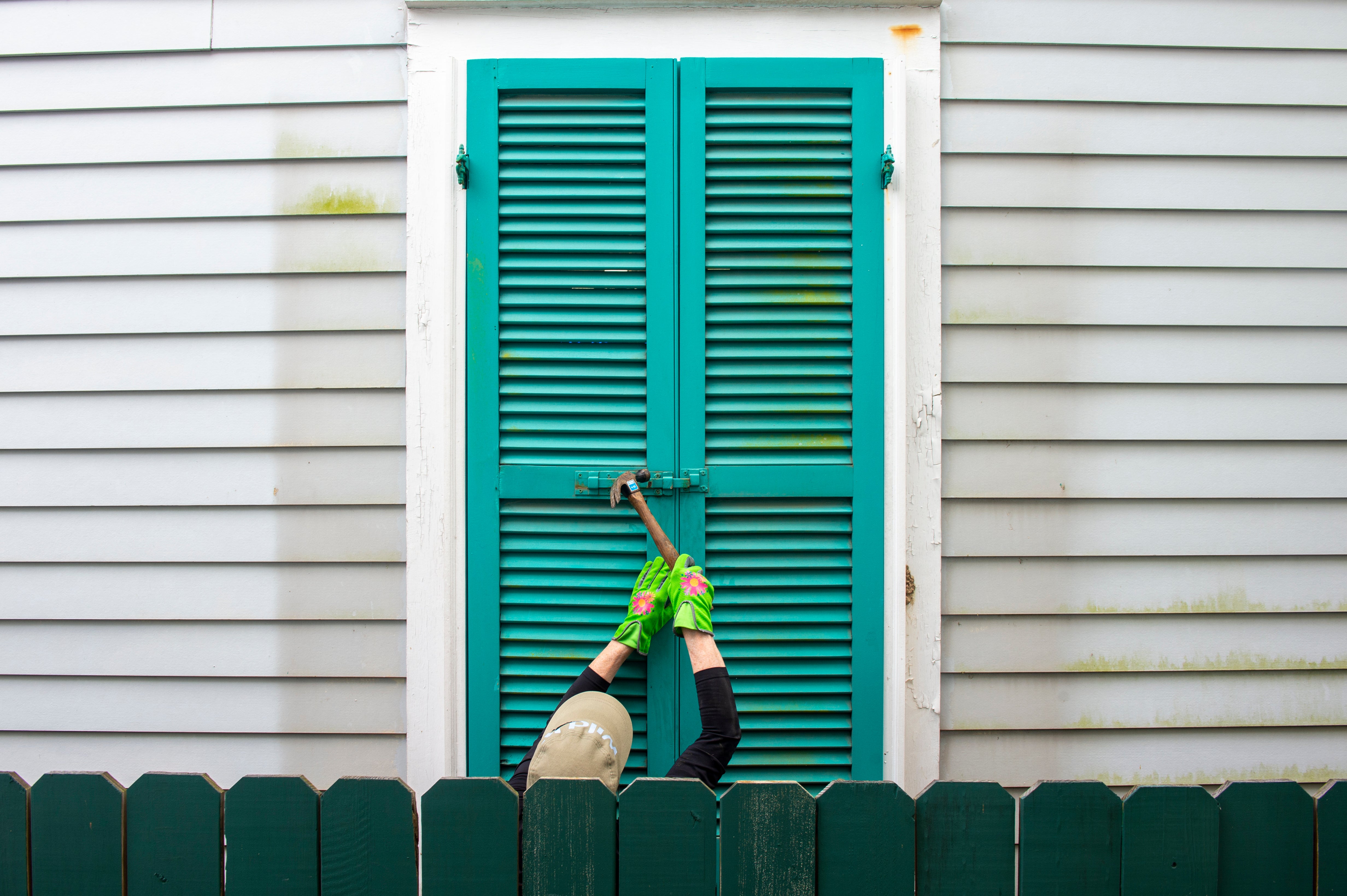 Storm shutters are hammered closed on a 100-year-old house, Friday, August 27, 2021, in New Orleans, as residents prepare for Hurricane Ida on.