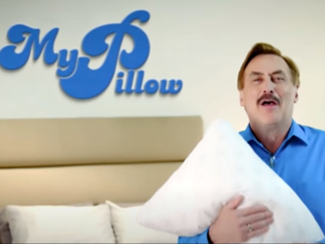 Mike Lindell, the CEO of MyPillow, hugs one of his pillows in a television advertisement.