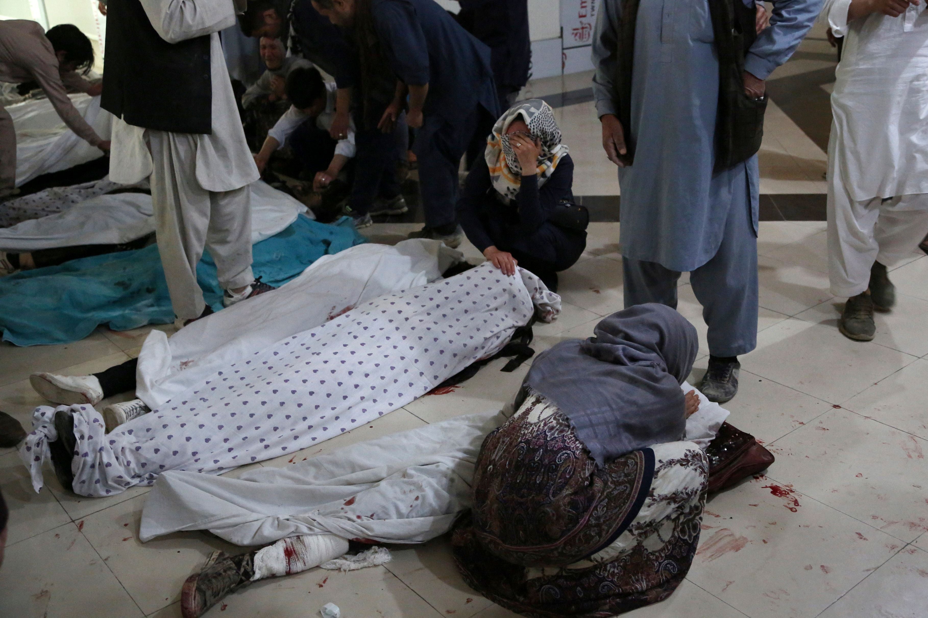 Relatives mourn victims who died in a blast outside a school in the west Kabul district of Dasht-e-Barchi in May