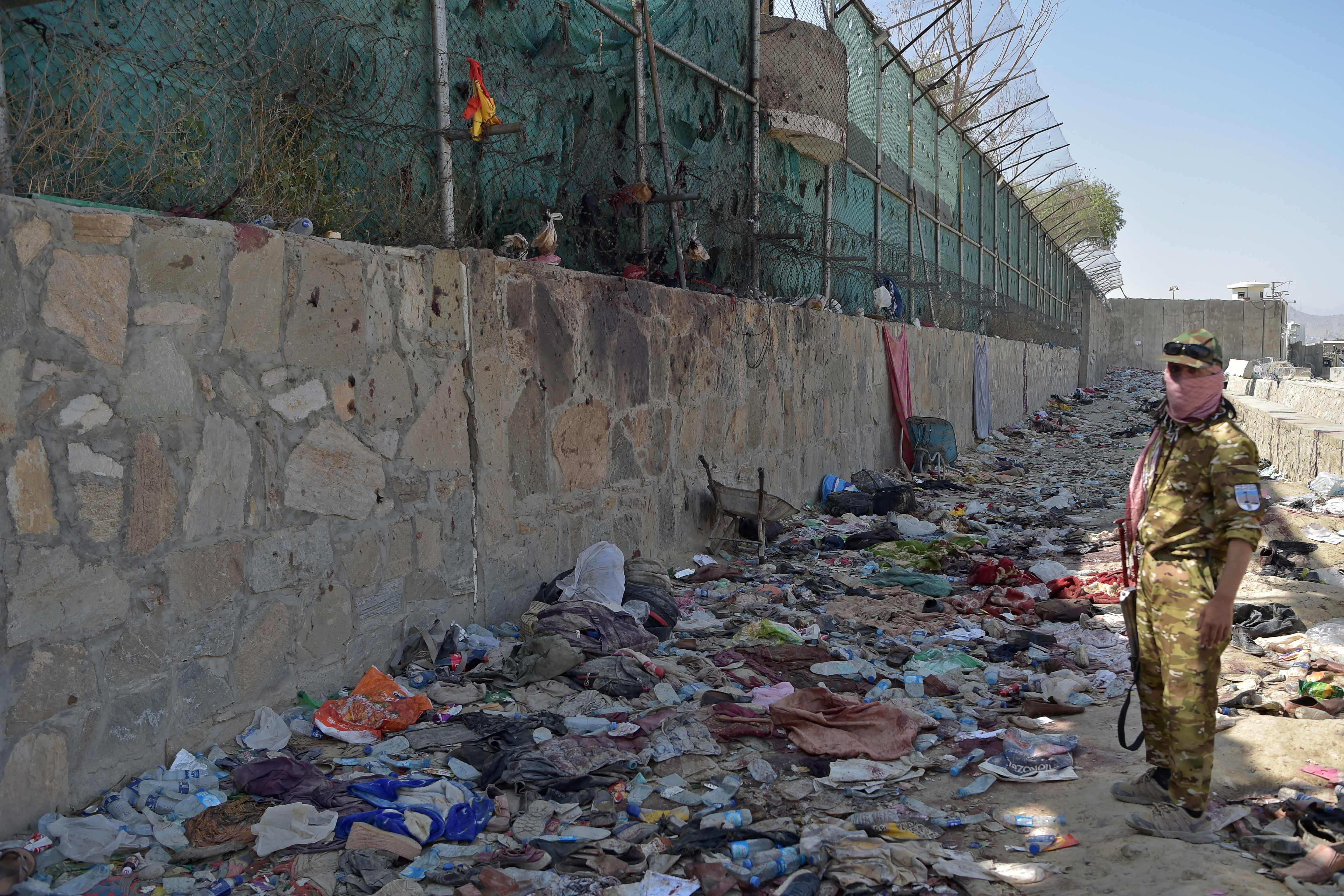 A Taliban fighter stands guard at the site of the 26 August twin suicide bombs outside Kabul airport