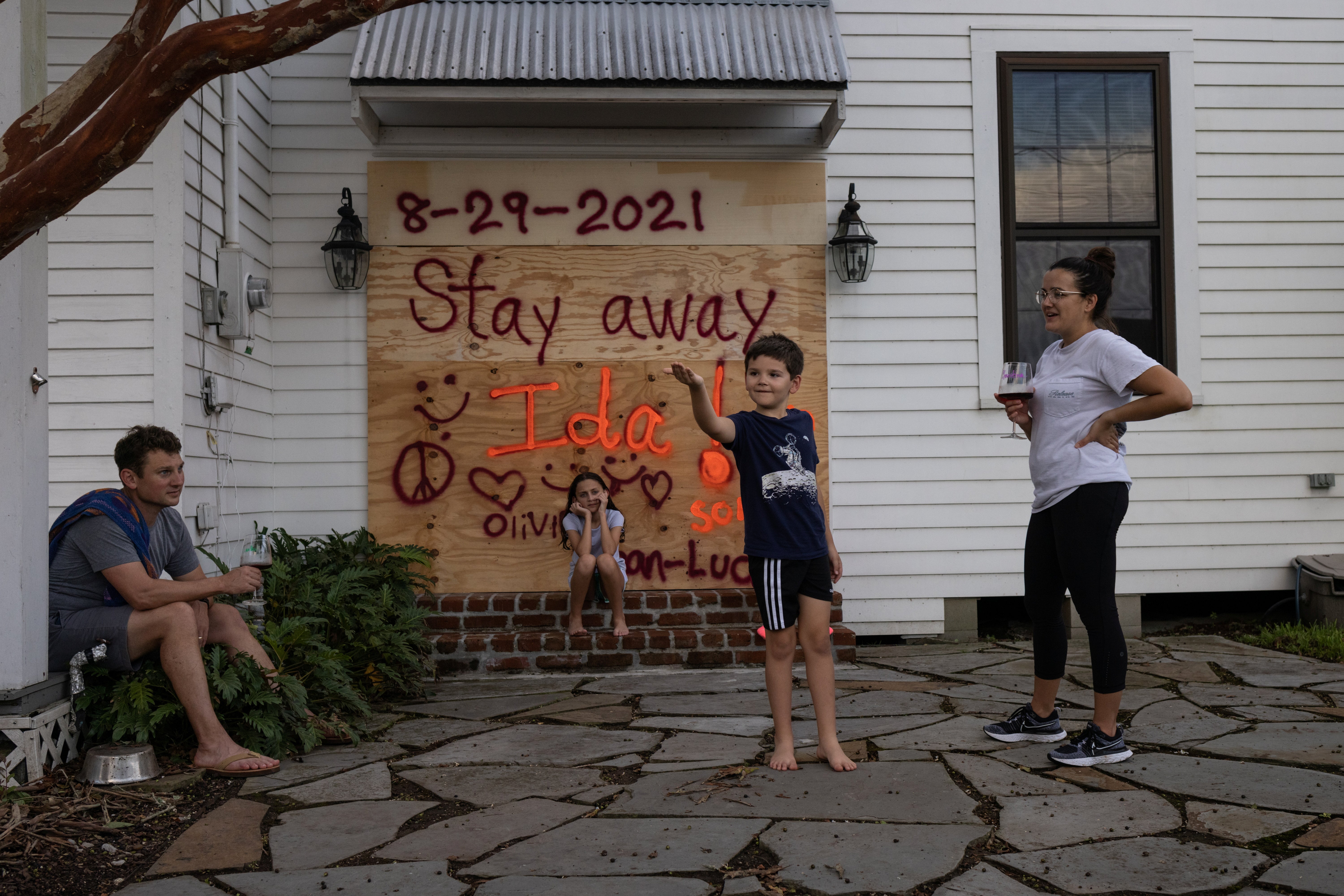 Jean-Luc Bourg, 8, his sister Olivia, 10, and parents Jean Paul and Christina have boarded up their property in preparation for Hurricane Ida in Morgan City, Louisiana