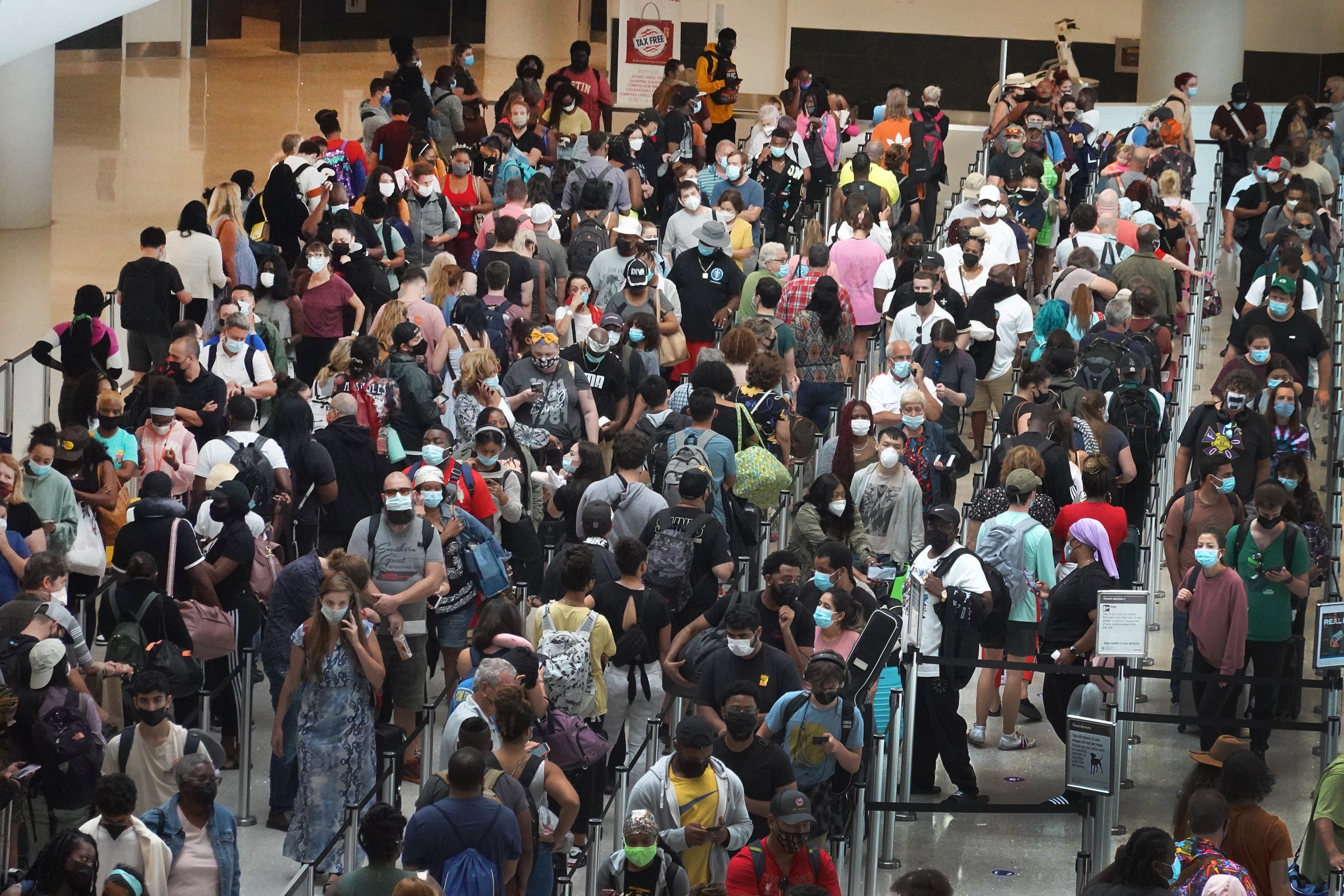 People stand in line to get through the TSA security checkpoint at Louis Armstrong New Orleans International Airport in August 2021. The airport has seen nearly 100 cancellations on Wednesday morning. It is not the only Louisiana airport affected by the storm.