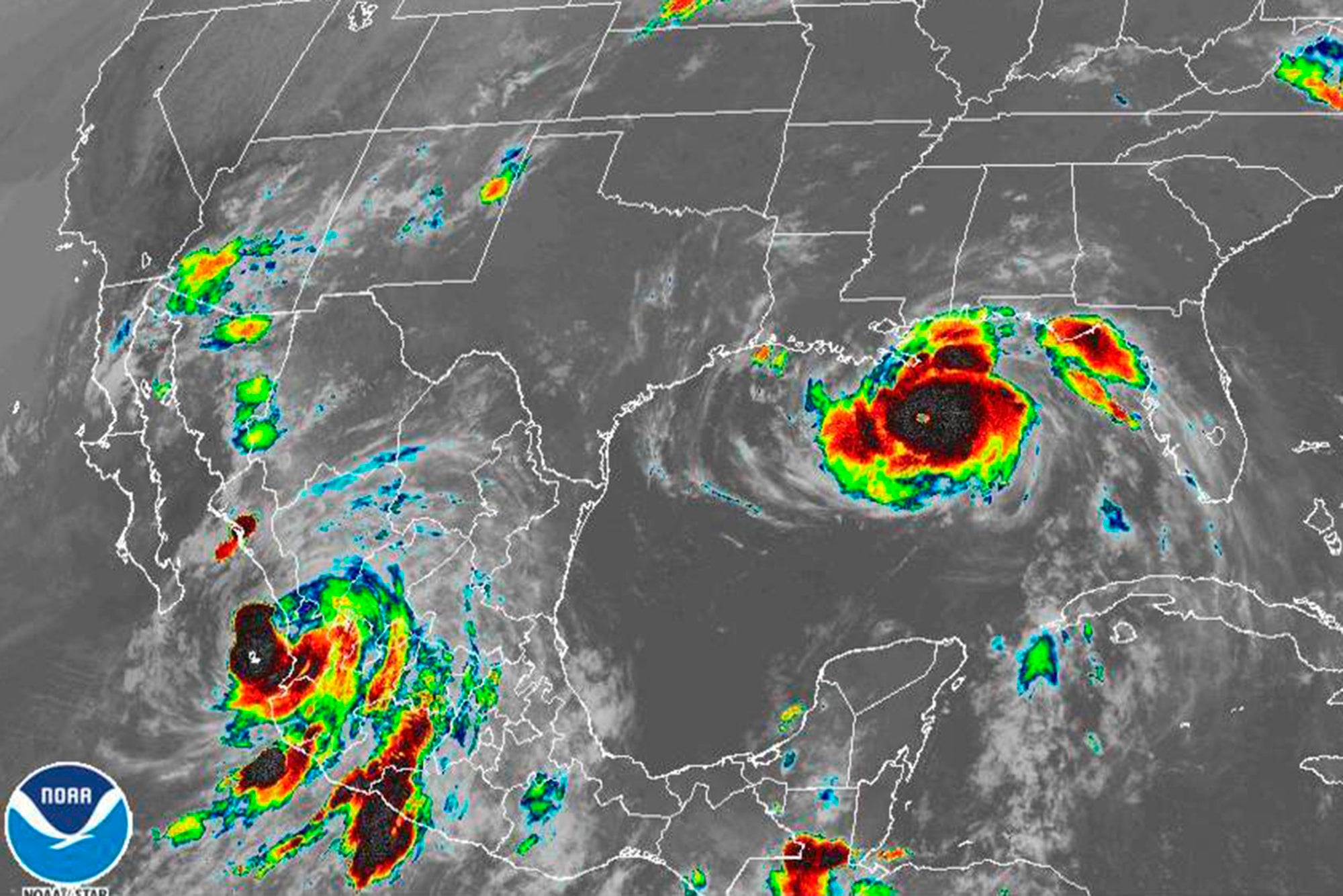 This image provided by the National Oceanic and Atmospheric Administration (NOAA) shows severe weather systems, Hurricane Nora, lower left, and Hurricane Ida, right, over the North American continent