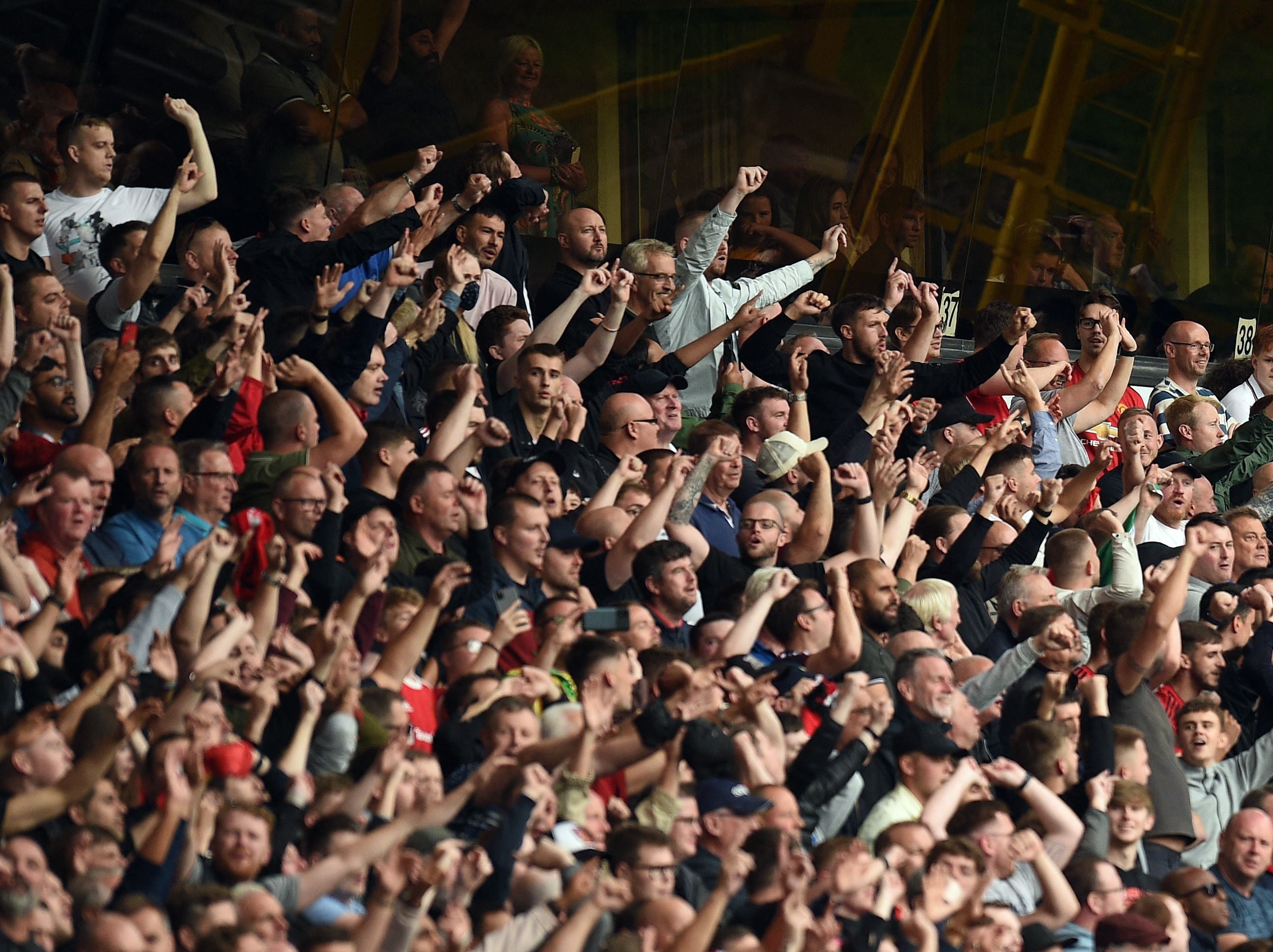 Many football fans stand in areas of seating