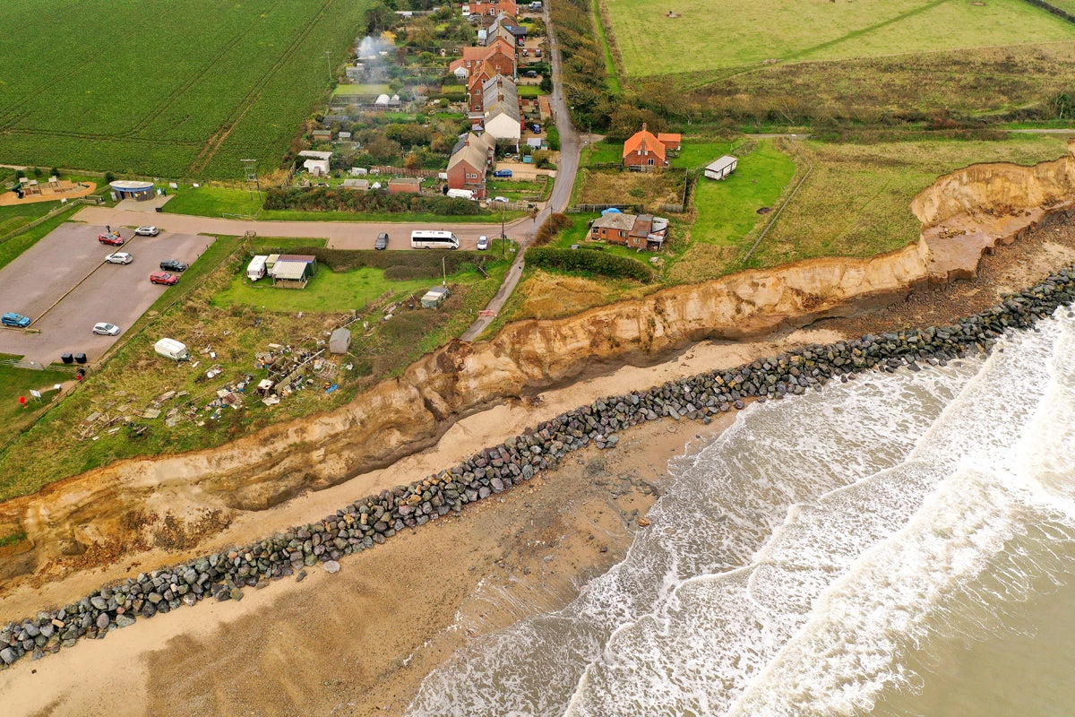 The end of a tarmac road highlights the devastation caused by coastal erosion in the village