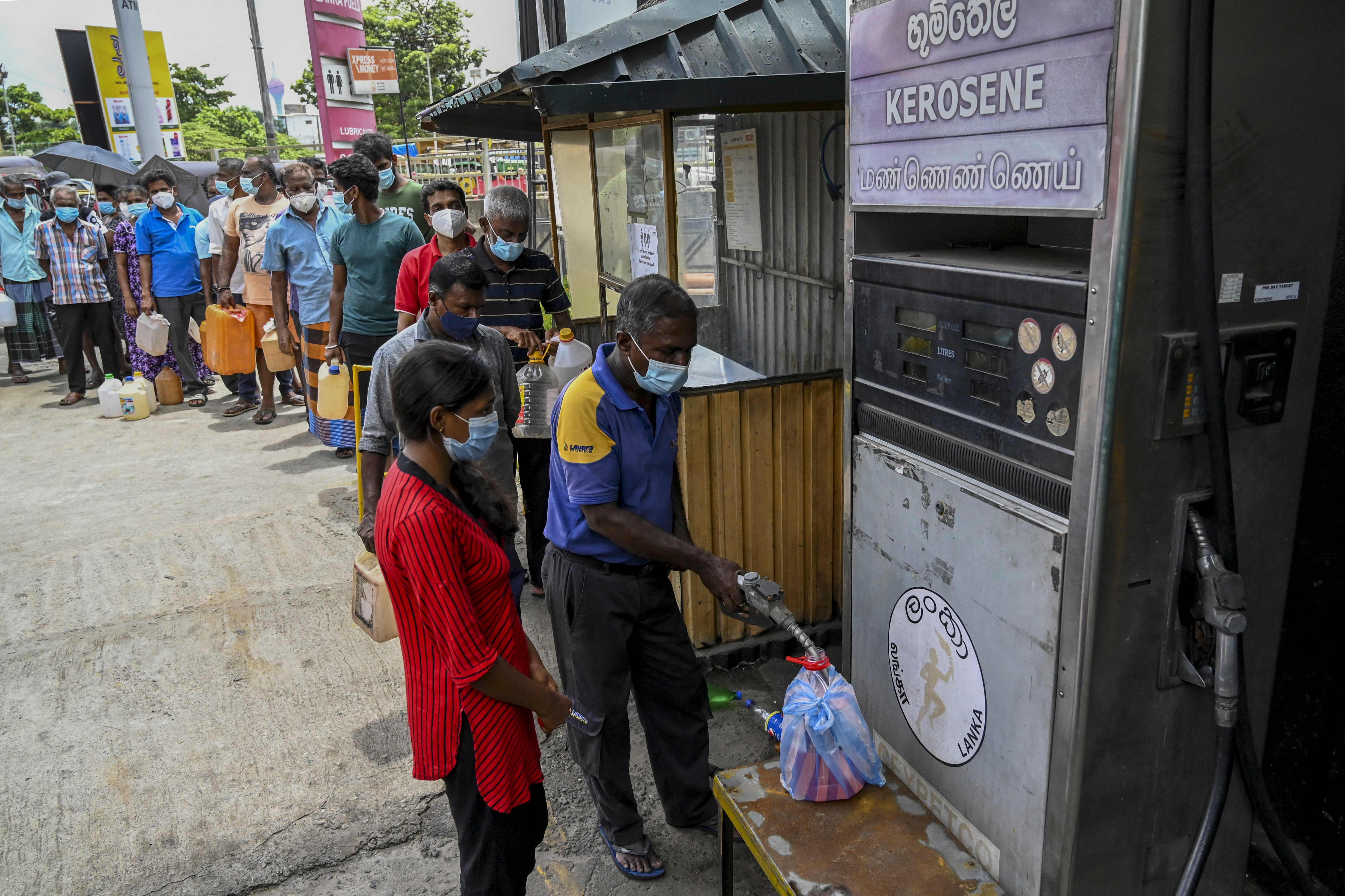 People stand in a queue to buy kerosene oil used in cooking stoves in Colombo following Sri Lanka’s declaration of a state of emergency