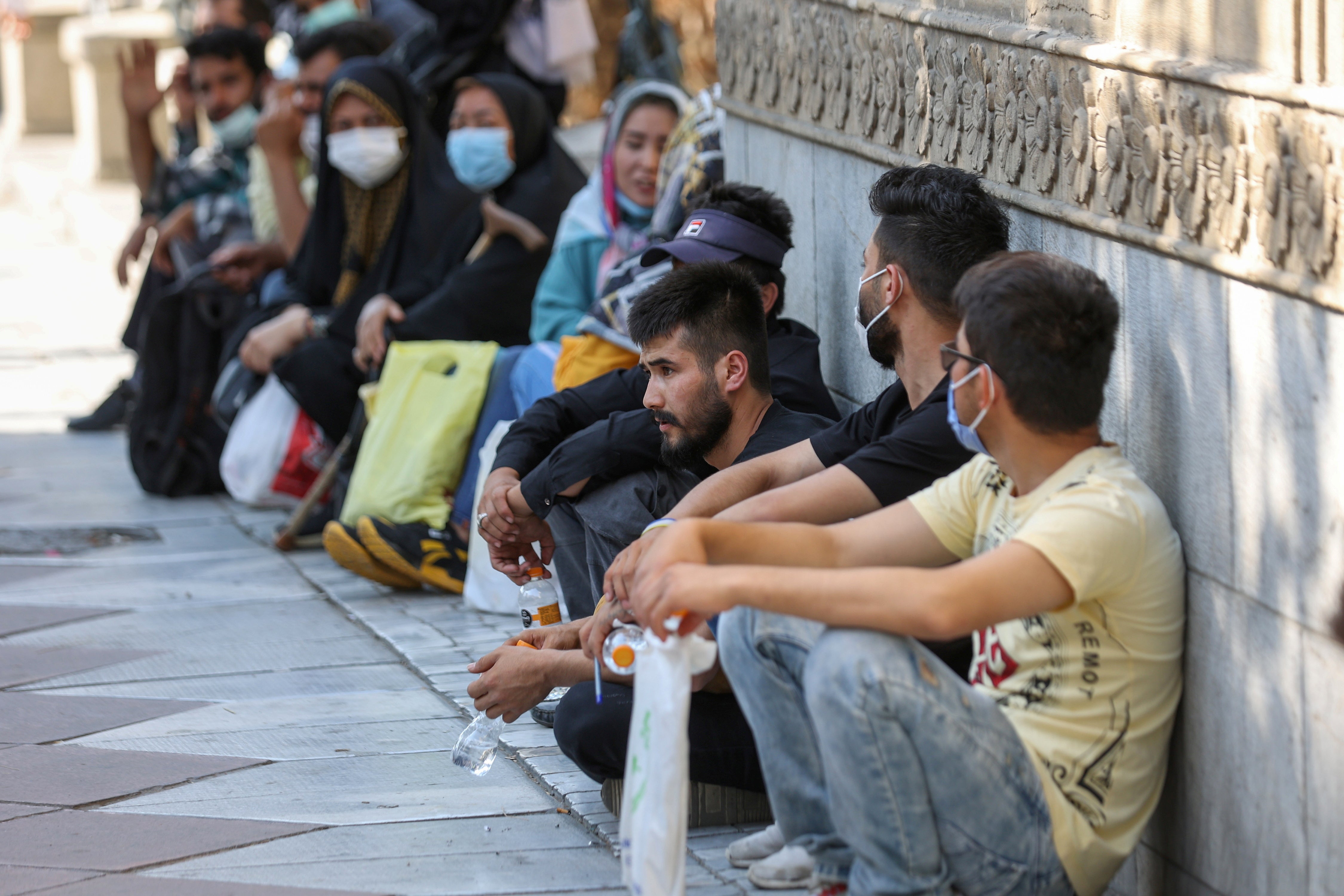 Afghan nationals gather in front of the German embassy in Tehran